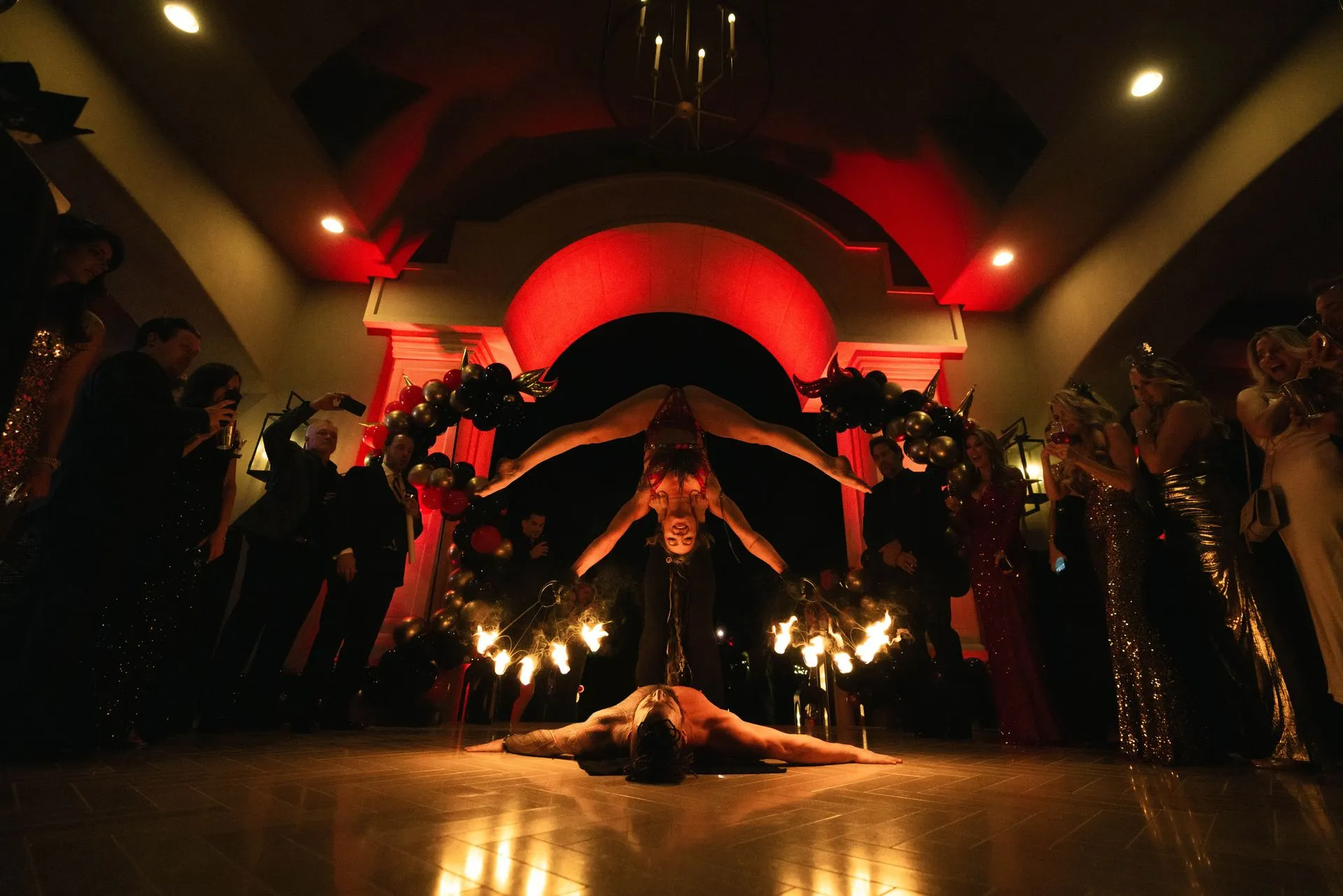A woman is doing a handstand on a stage in front of a crowd