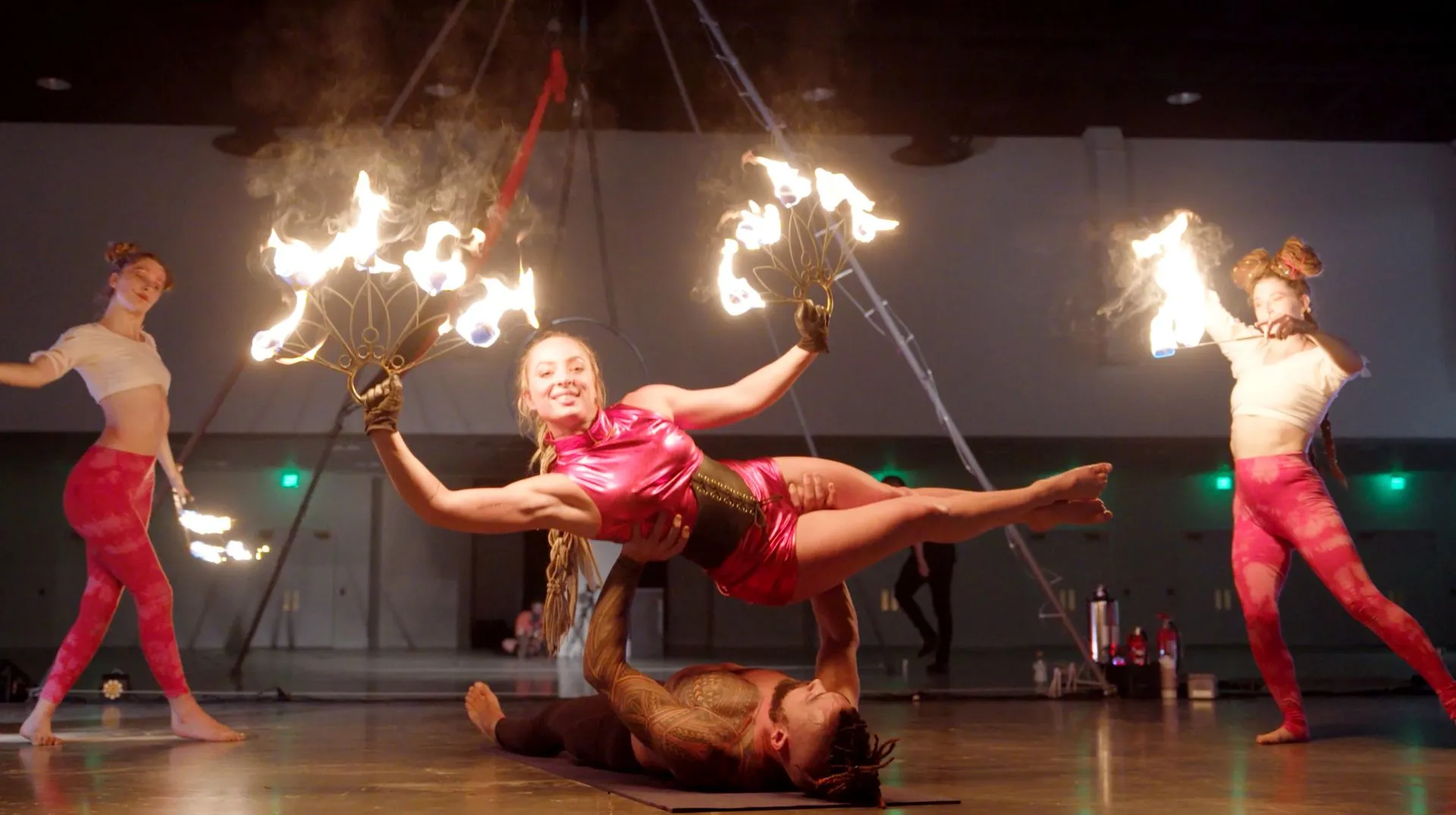 A group of people are performing aerial acrobatics with fire.