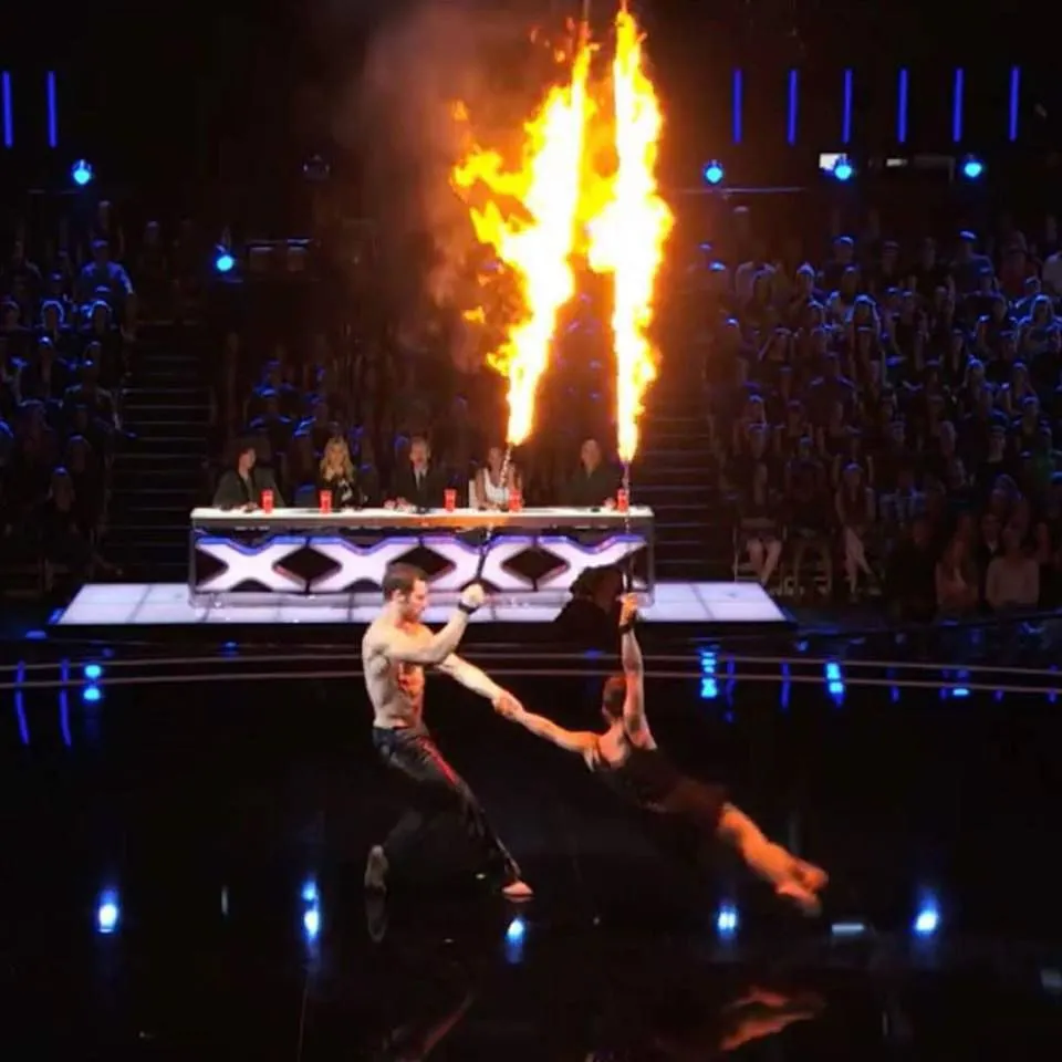 A man is holding a woman 's hand with flames coming out of it