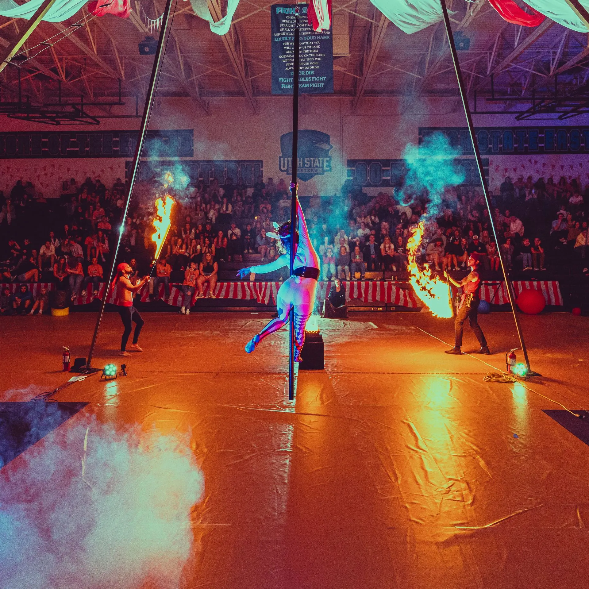A group of people are performing aerial acrobatics in front of a crowd