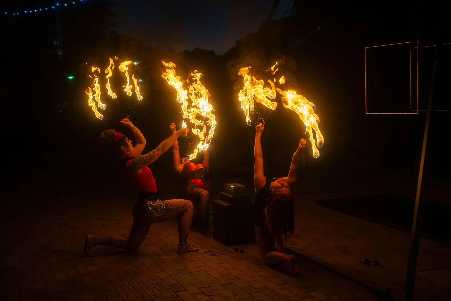 A group of people are performing a fire show at night.