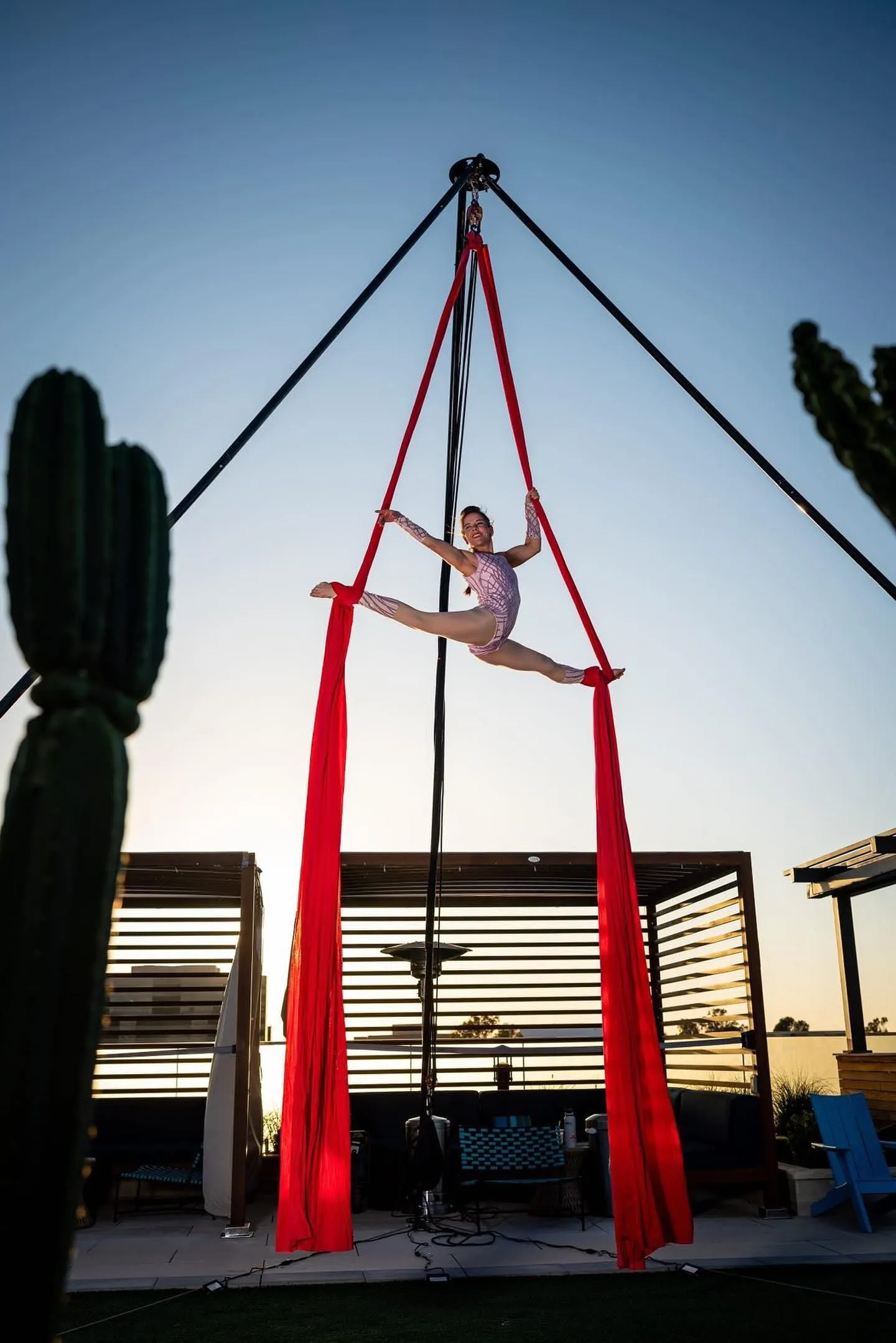 A woman is performing aerial acrobatics on a red cloth