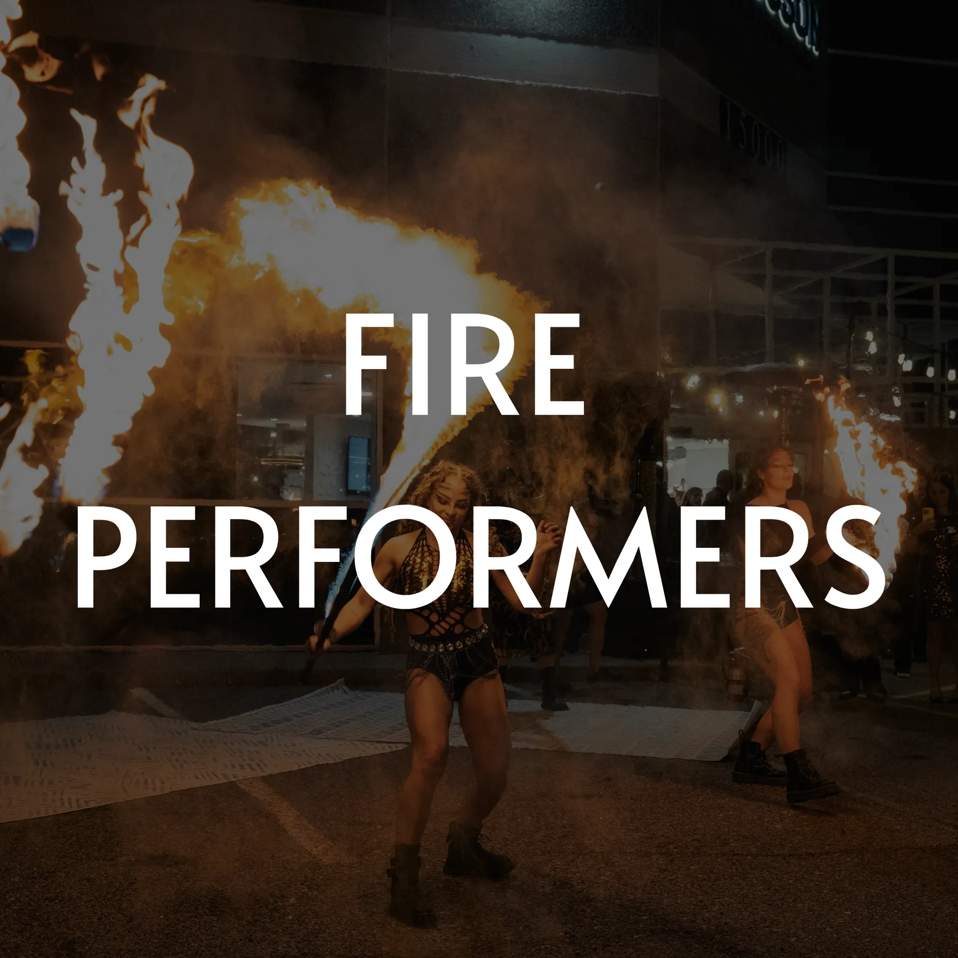 Fire performers at night, wielding torches and flaming objects.