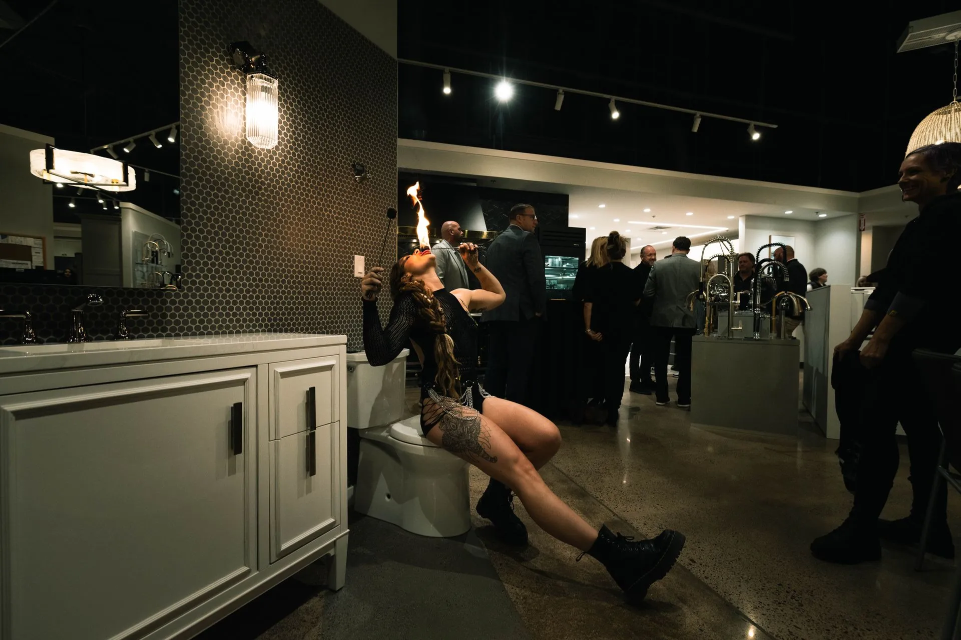 A woman is sitting on a toilet in a bathroom.