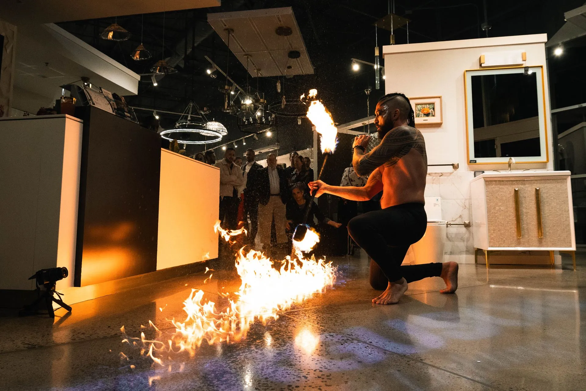 A man is kneeling down in front of a fire torch.