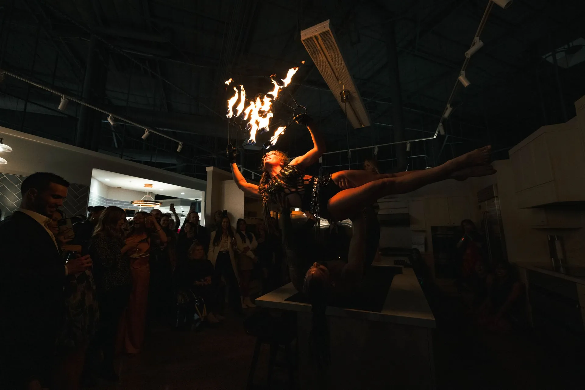 A woman is holding a torch in her hand in front of a crowd of people.