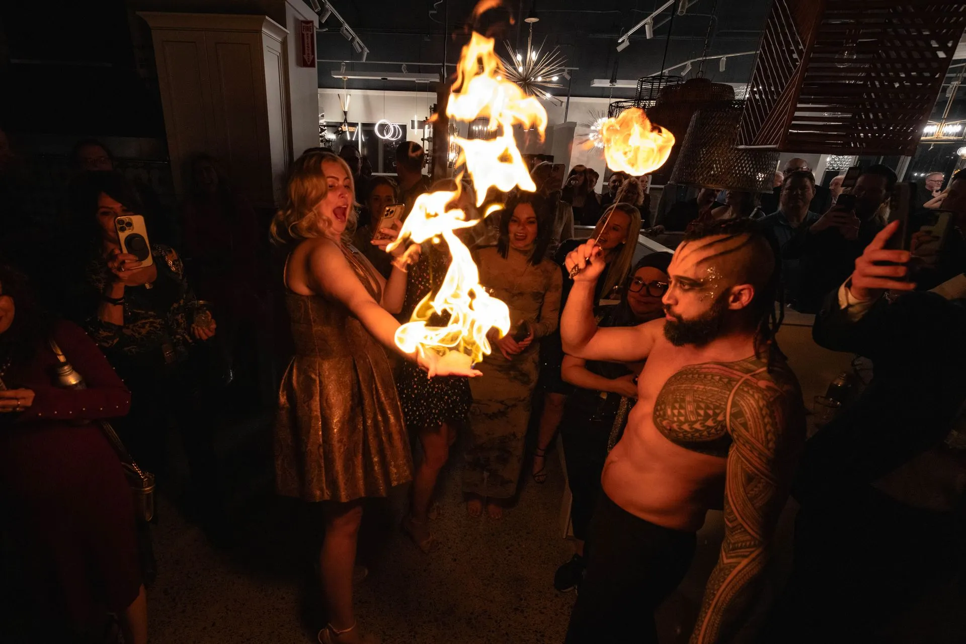 A man and a woman are holding a fire torch in a dark room.