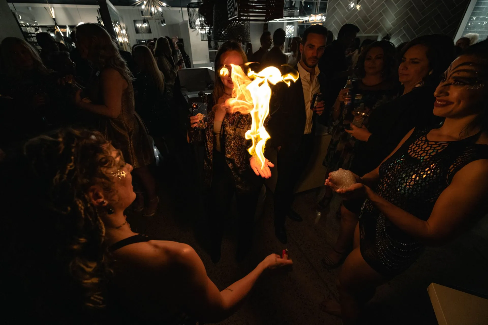 A woman is holding a torch with flames coming out of it.
