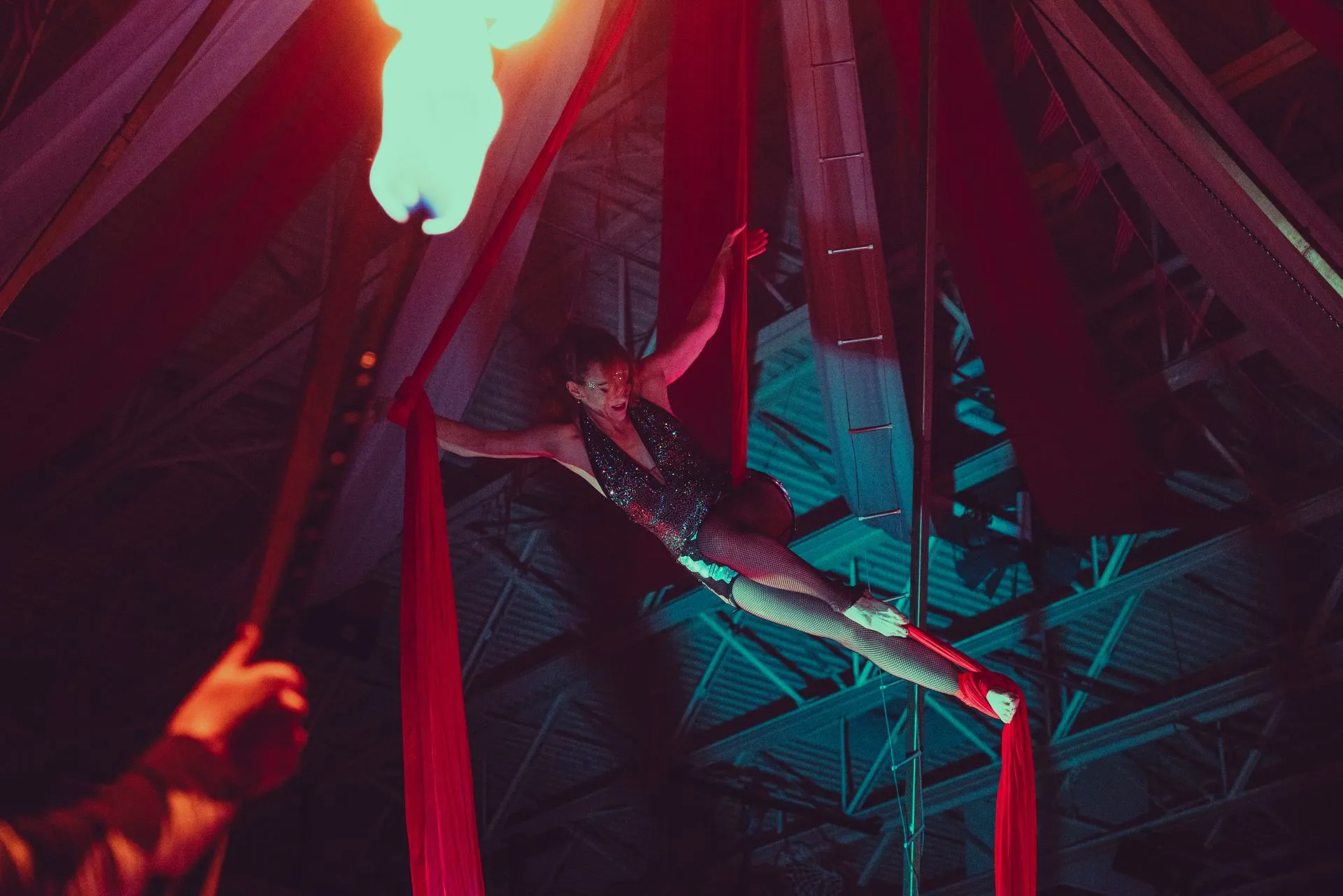 A woman is flying through the air while holding a fire torch.