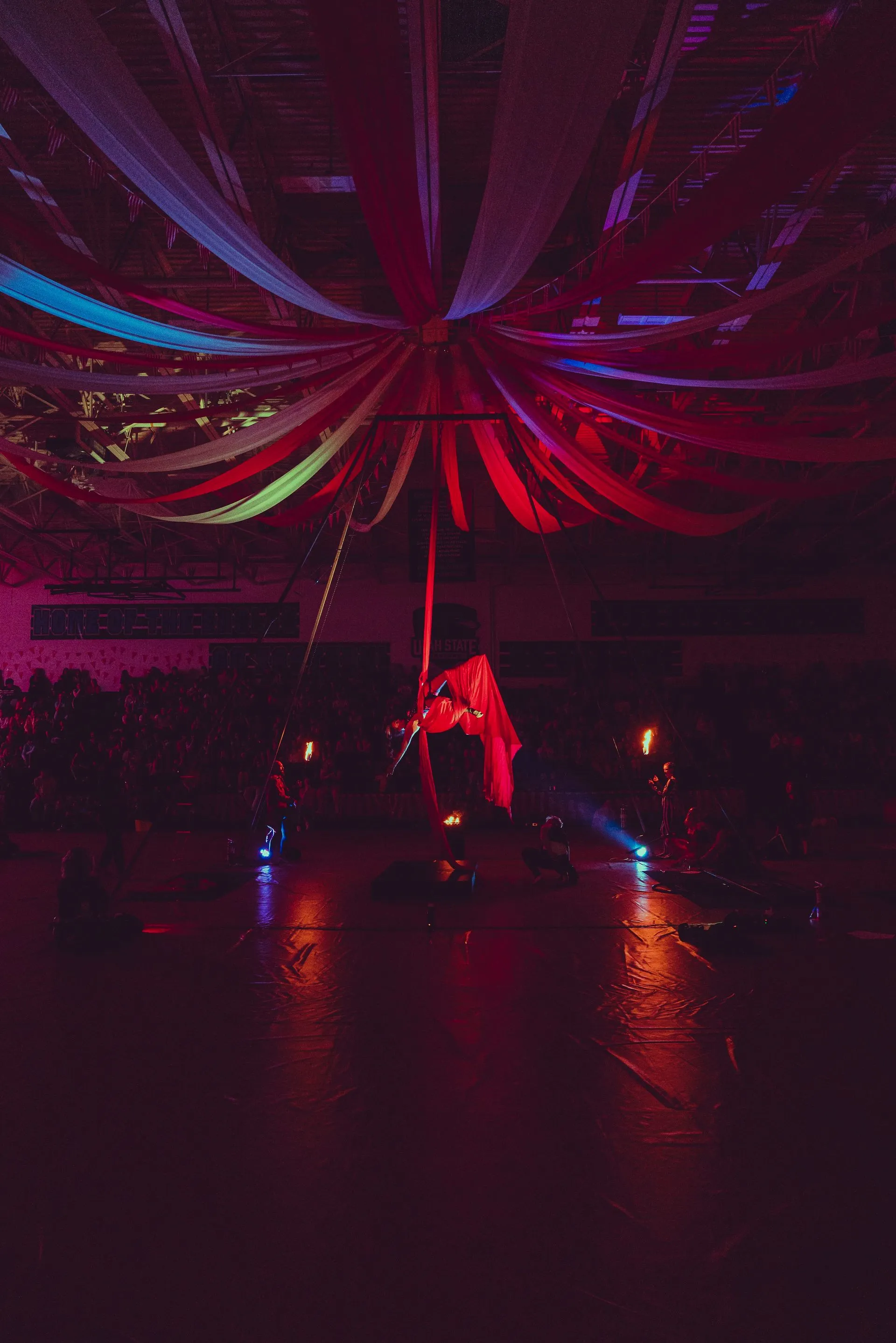 A woman is dancing on a pole in a dark room.