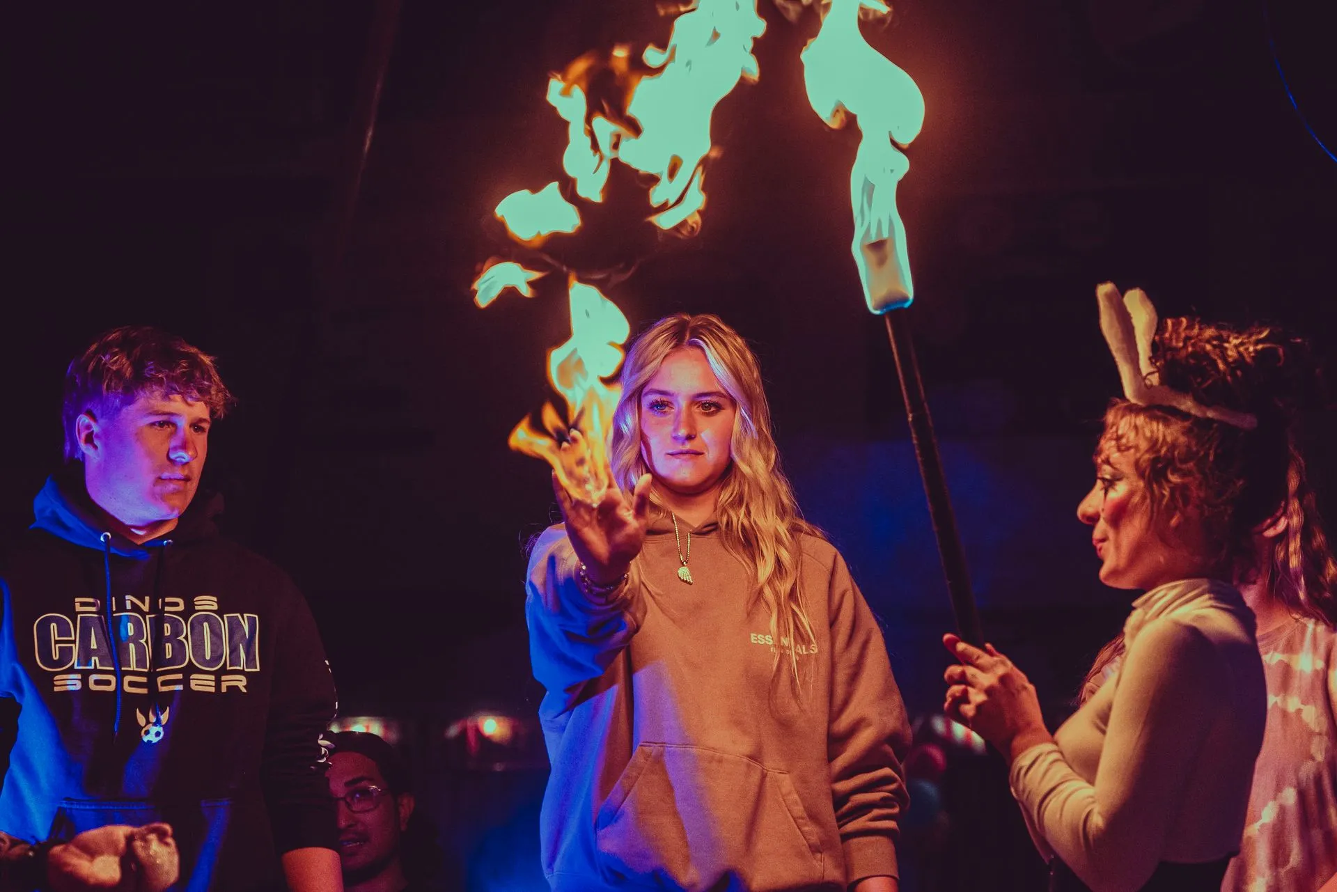A group of people are standing in front of a fire torch.