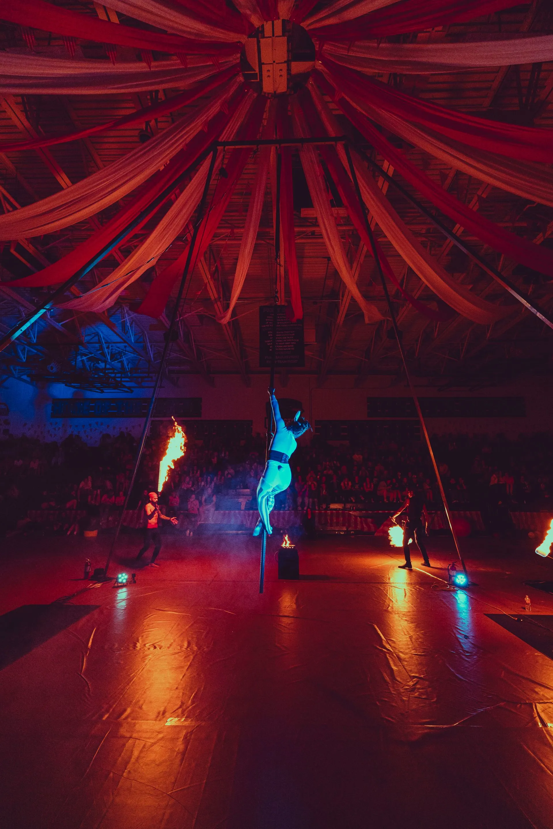 A person is standing on a pole with fire coming out of it.
