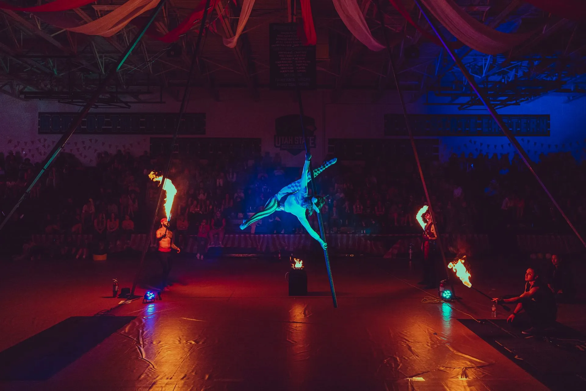 A group of people are performing a fire show in a dark room.
