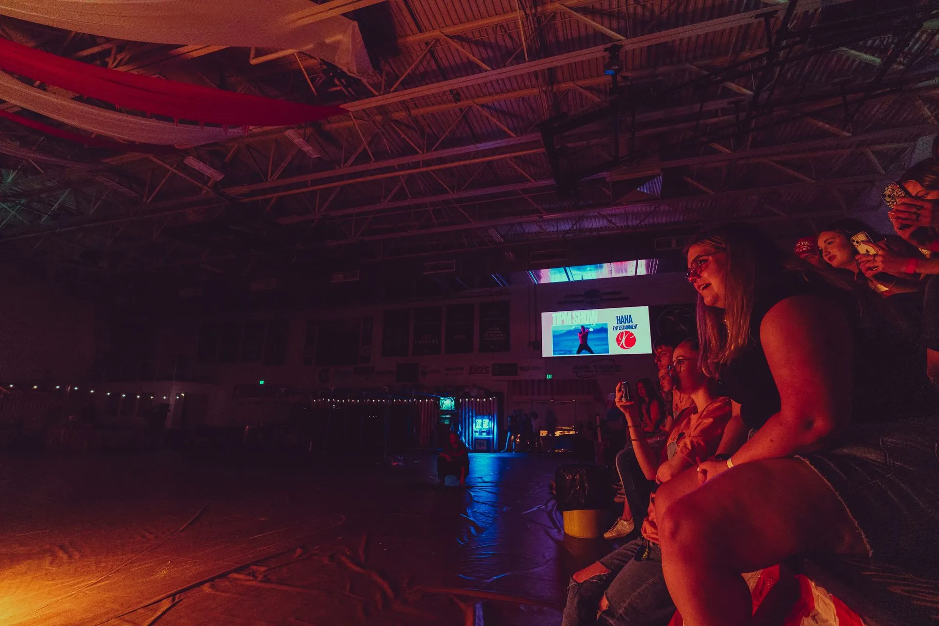 A group of people are sitting around a fire in a dark room.