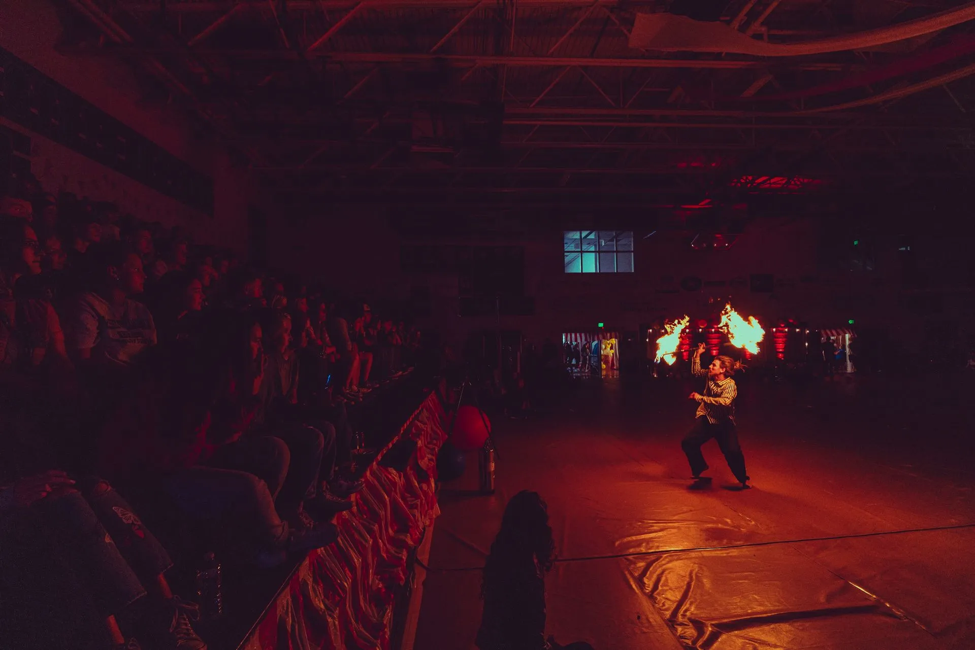 A man is standing on a stage in front of a crowd in a dark room.