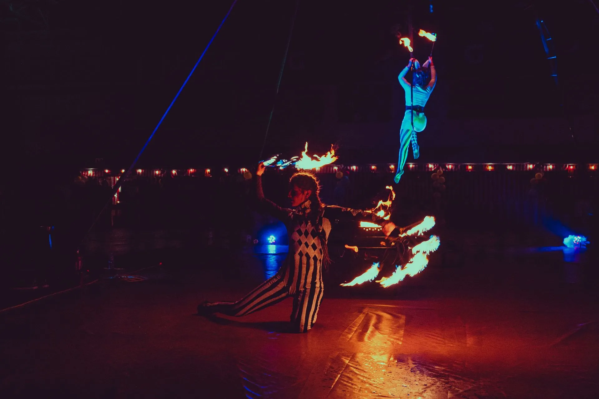 A group of people are performing a fire show in the dark.
