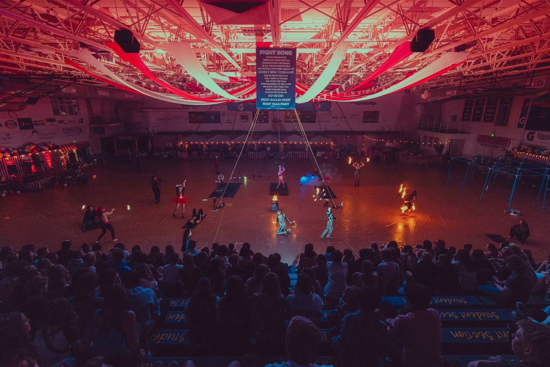 A crowd of people are watching a basketball game in a stadium.