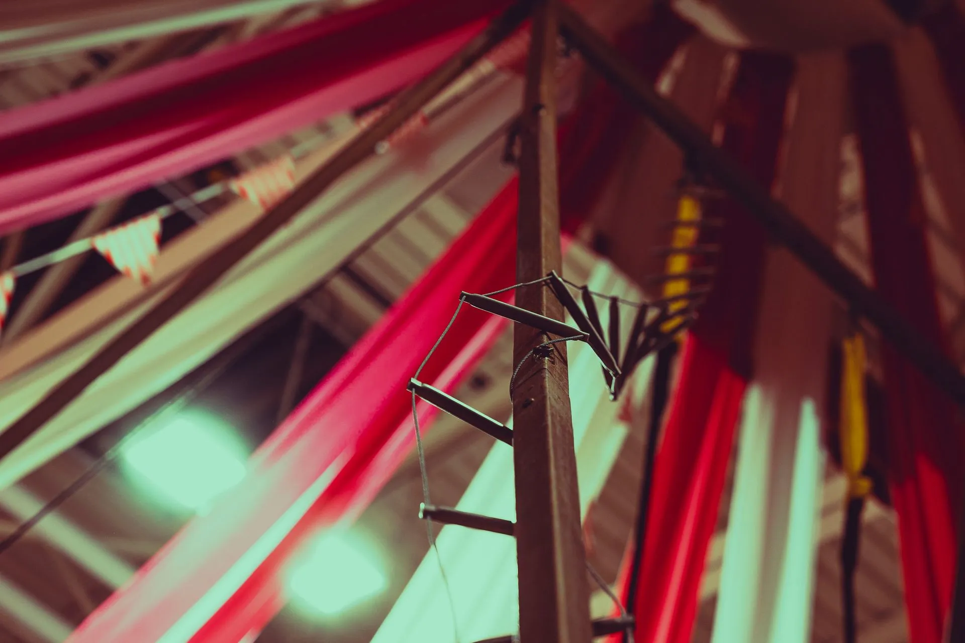 A close up of a ferris wheel with red and white flags hanging from the ceiling.