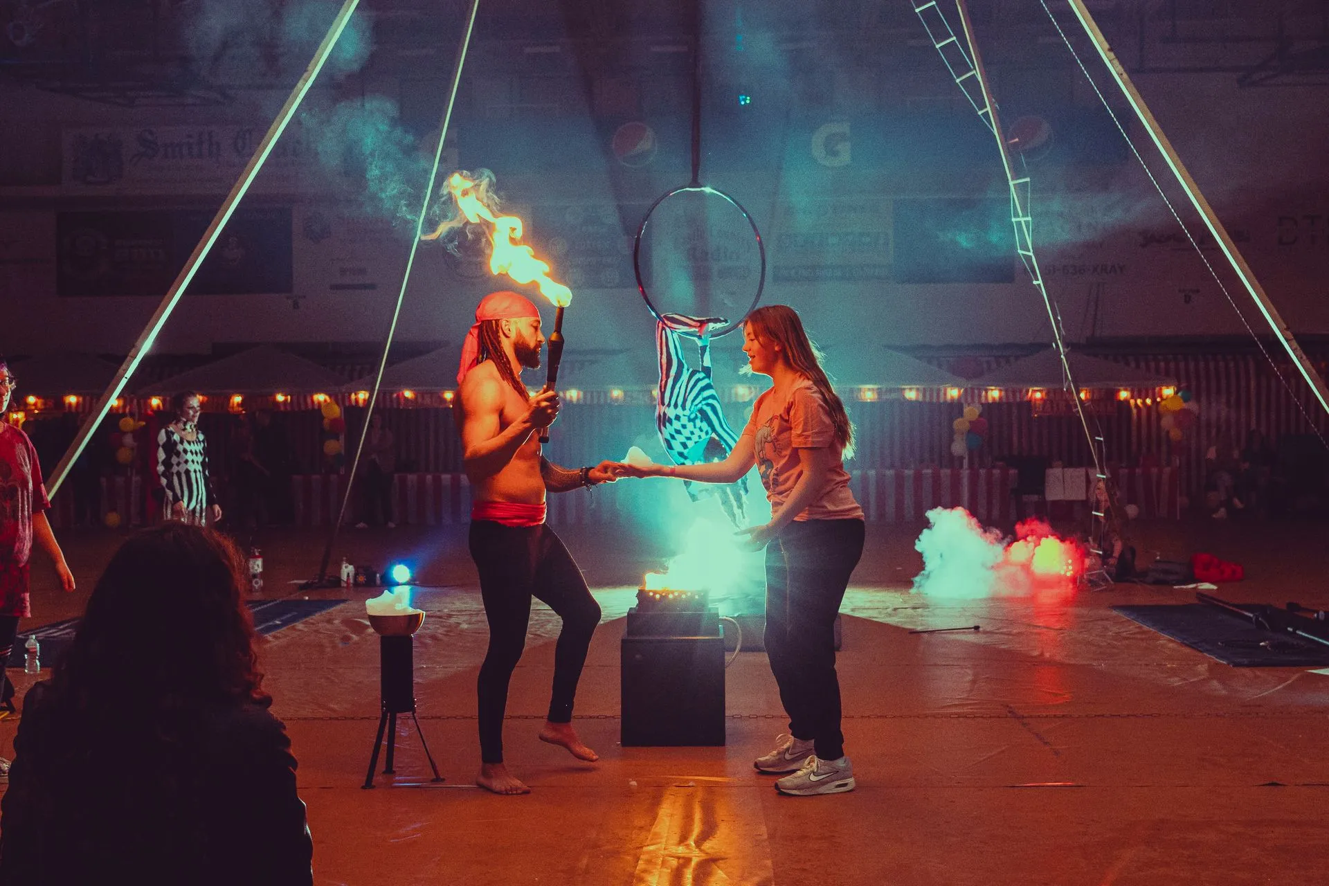 A man and a woman are holding hands in a circus tent.