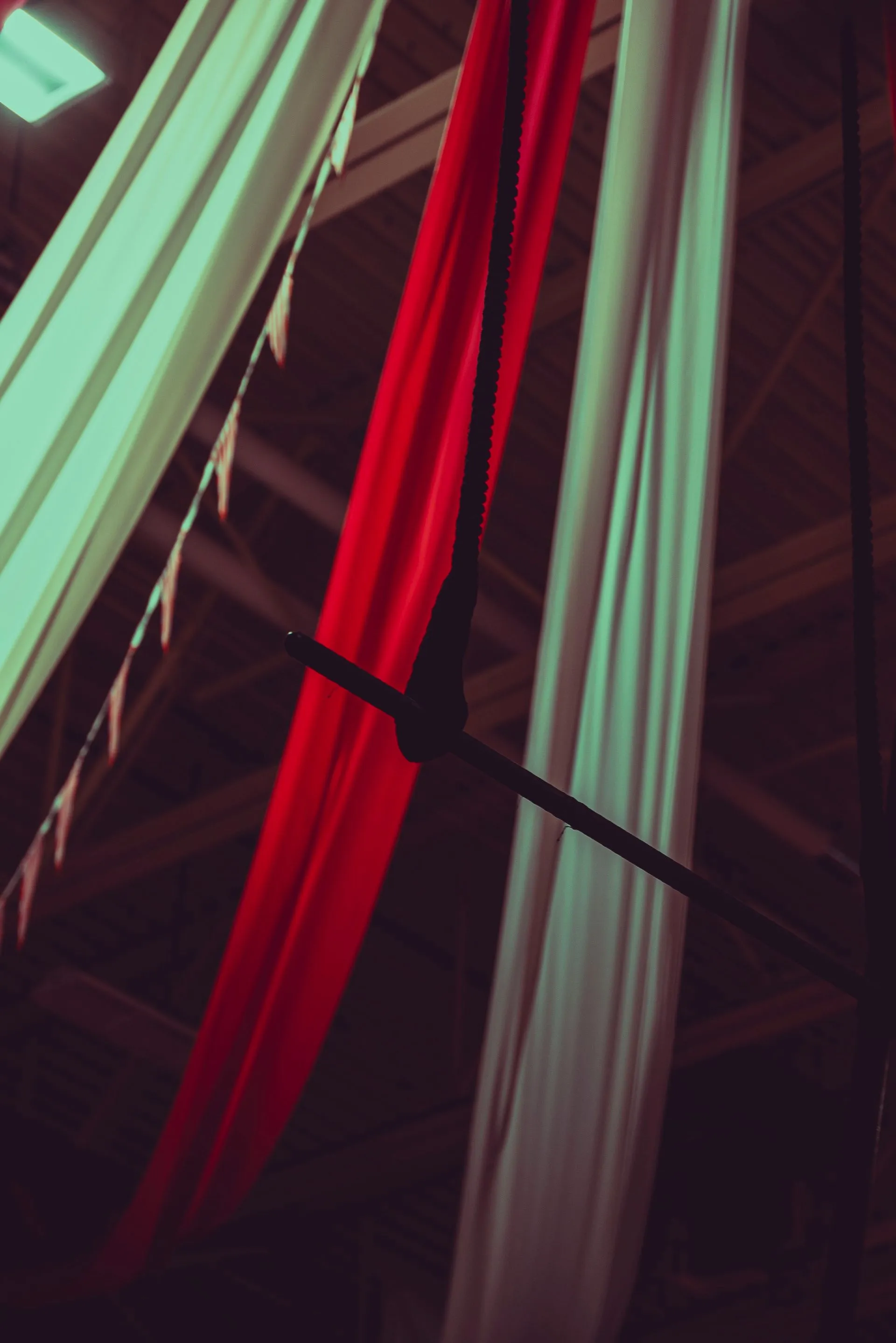 Red and white aerial silks hanging from the ceiling
