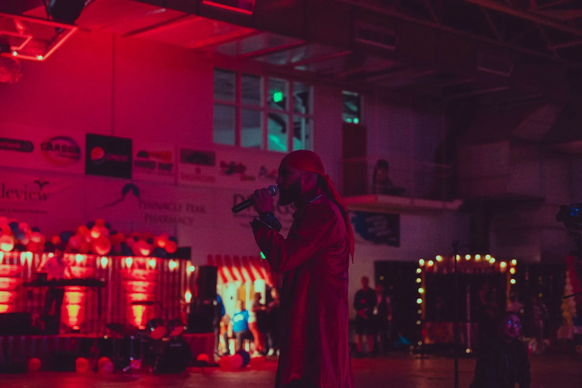 A woman is singing into a microphone in a dark room.