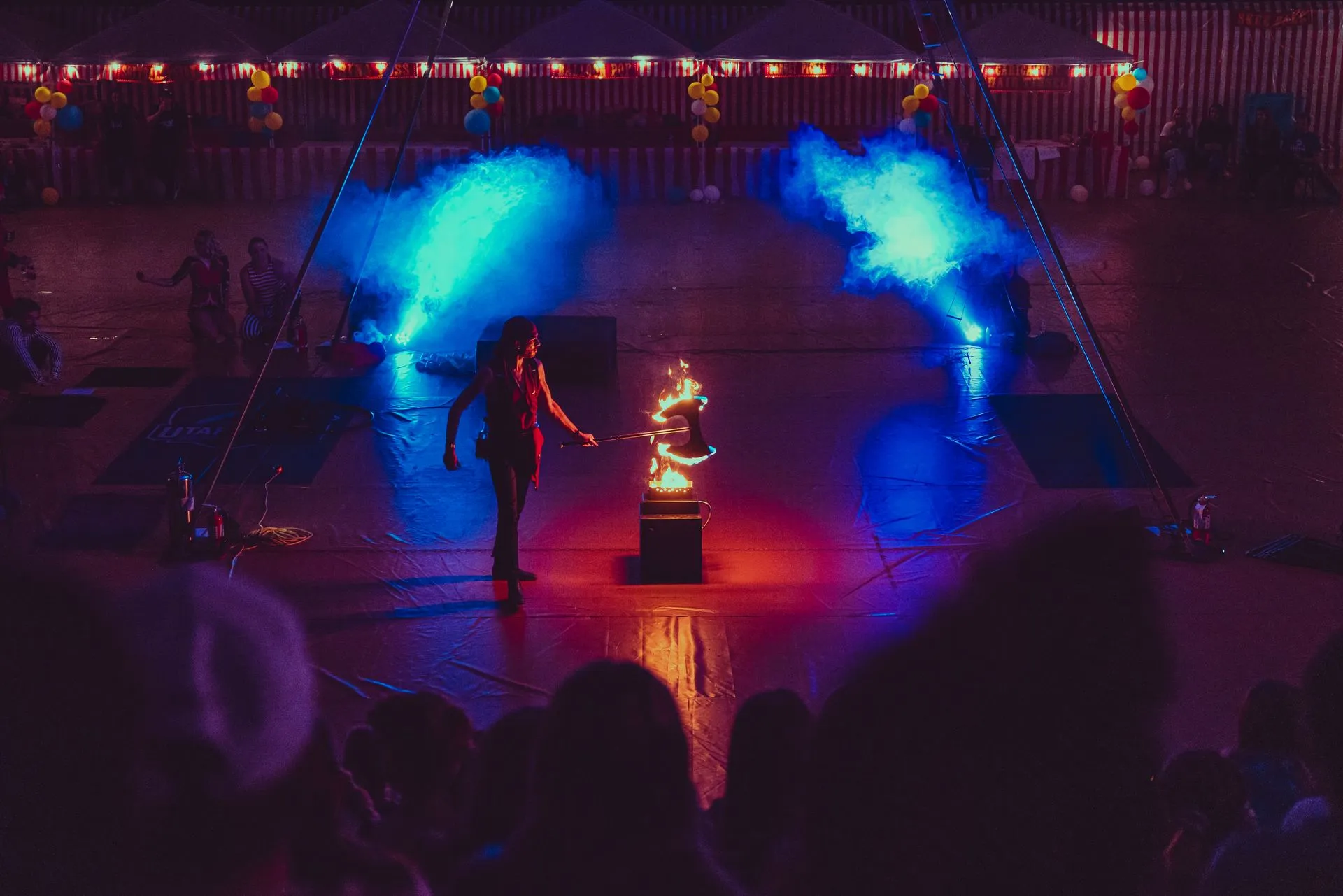 A woman is standing on a stage in front of a crowd of people.