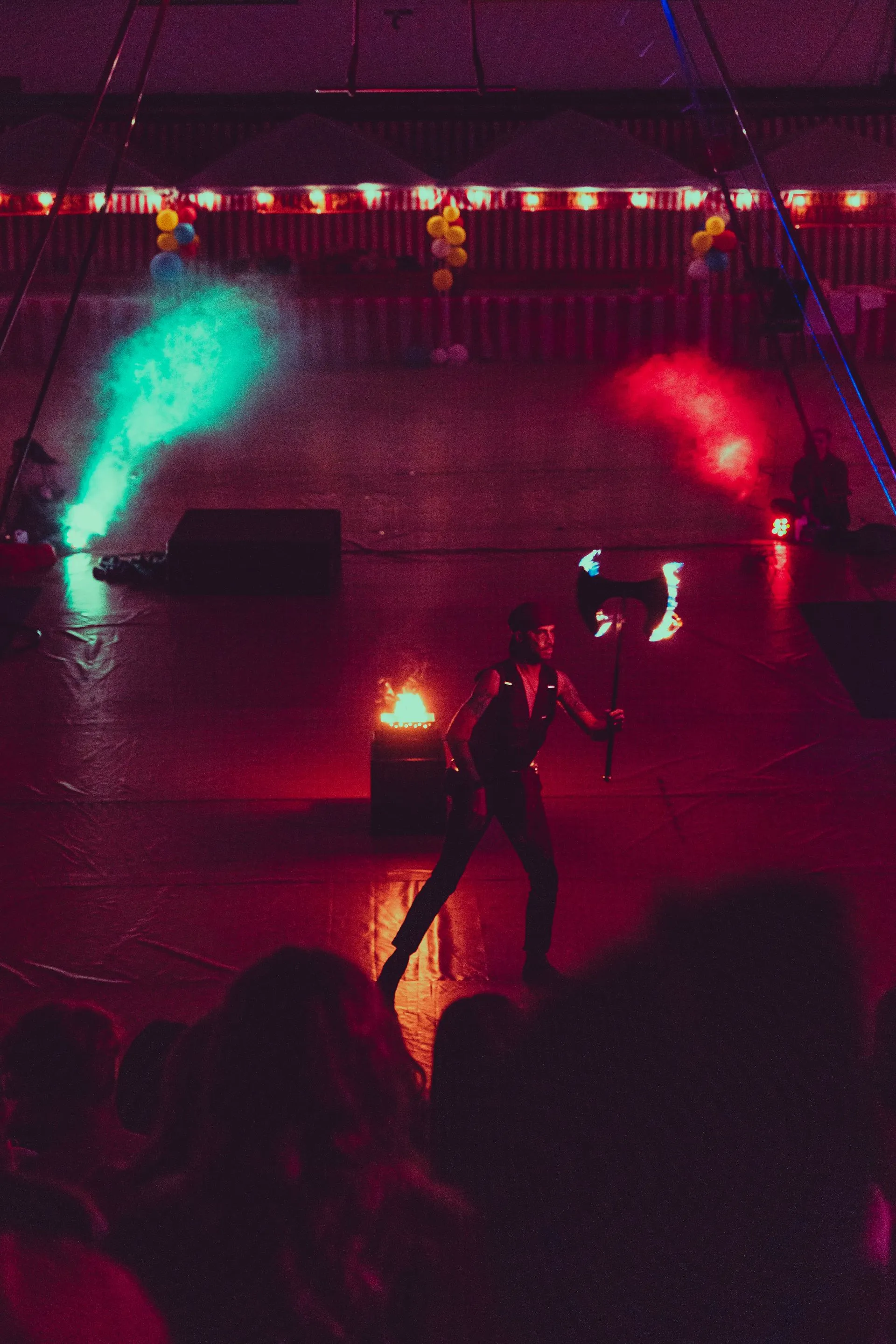 A man is holding a torch on a stage in front of a crowd