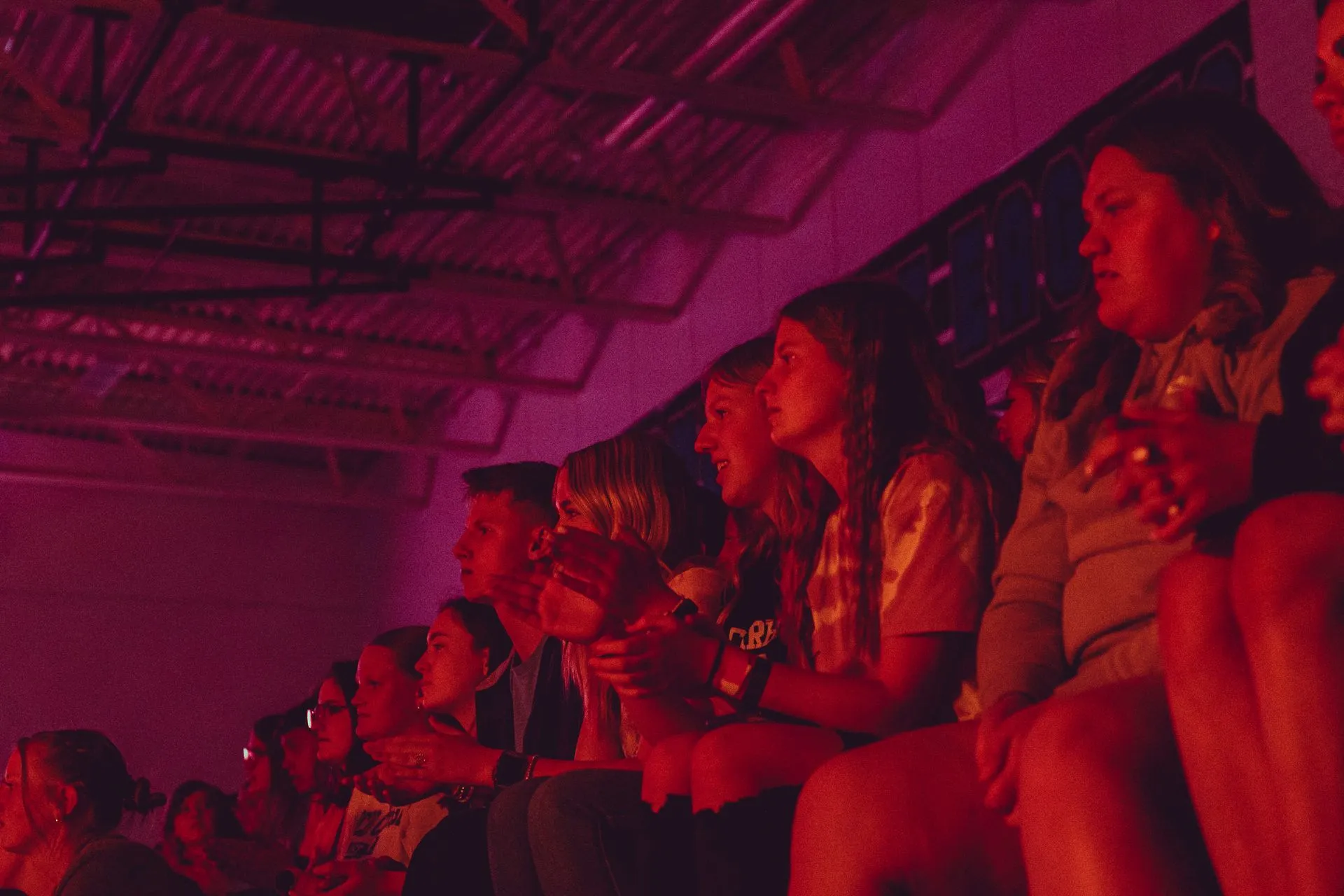 A group of people are sitting in a stadium watching a concert.