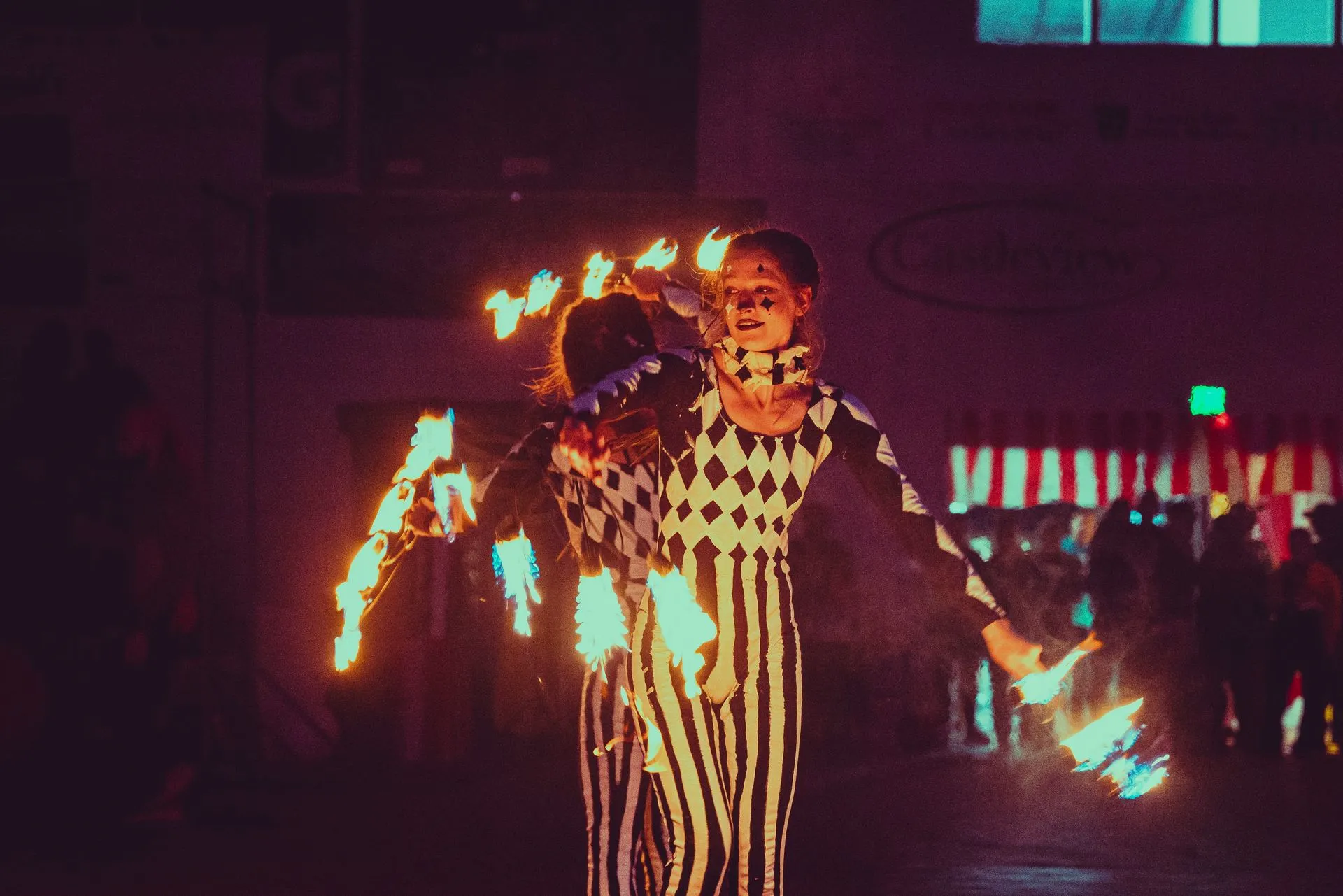 A man and a woman are holding fire in their hands in a dark room.