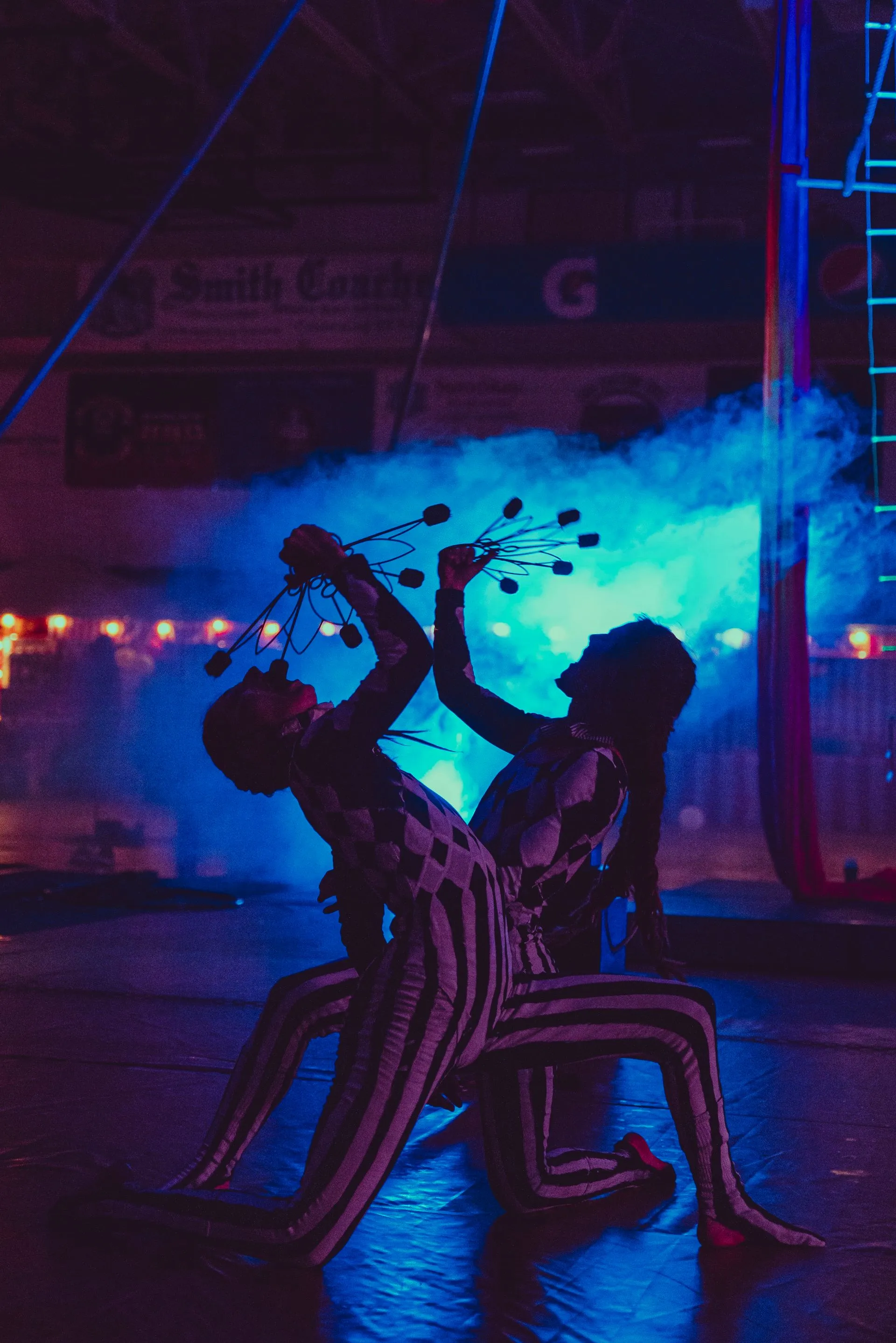 A couple of people are dancing in a dark room with blue lights.