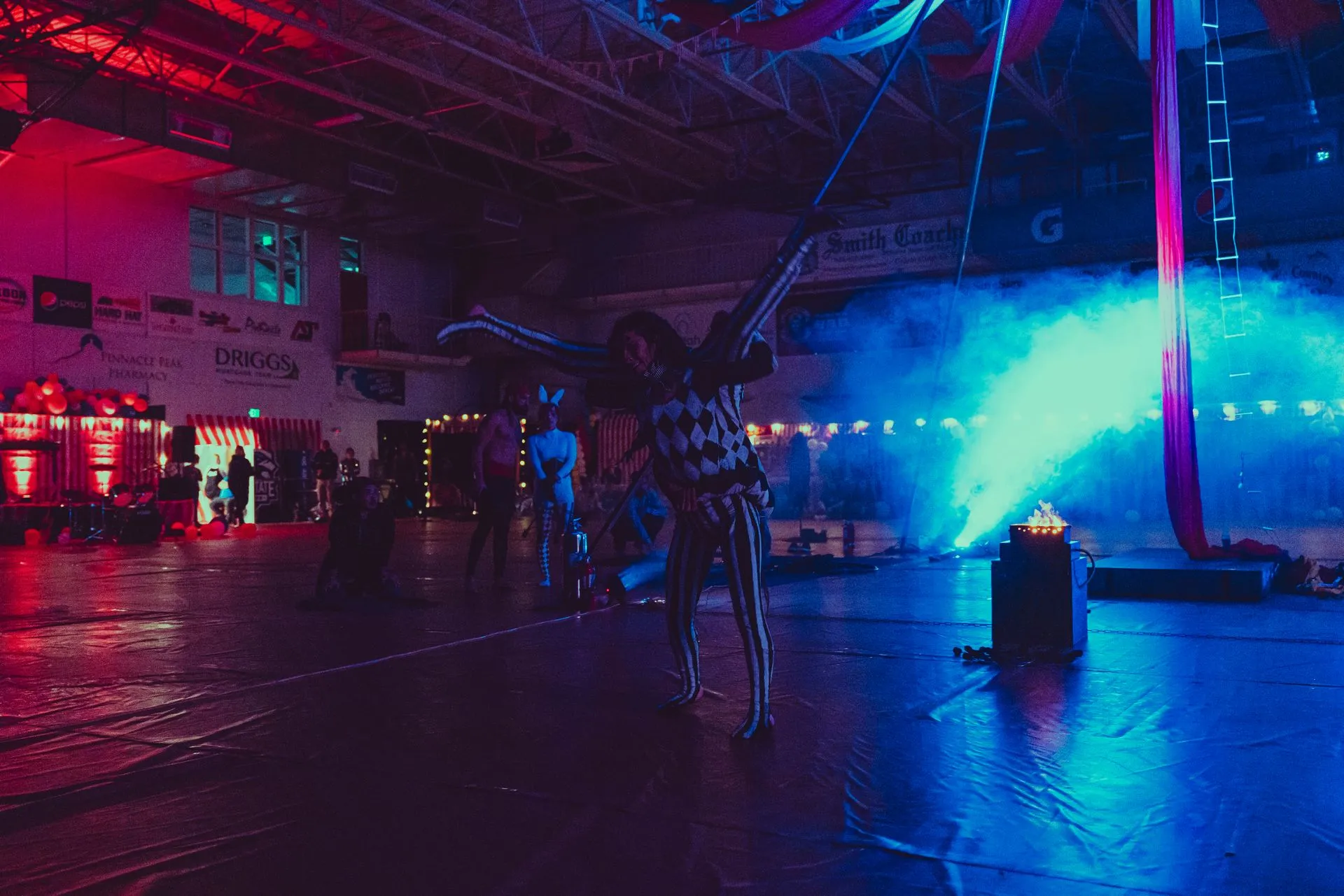 A group of people are standing in a dark room with blue lights.