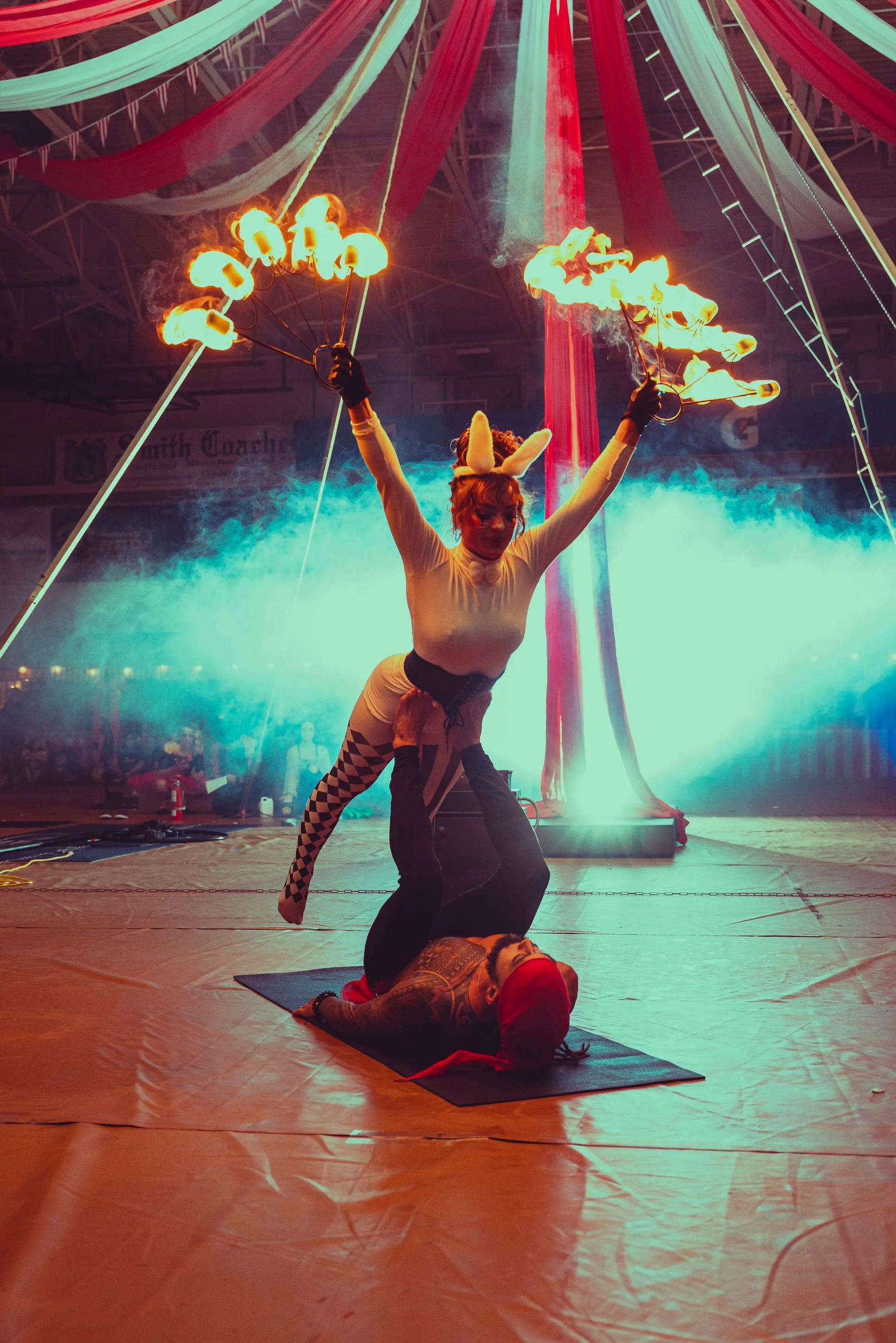 A female circus bunny performing acrobatics with fire.
