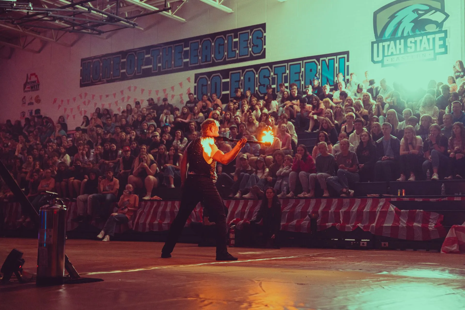A man is holding a torch in front of a crowd of people in a stadium.