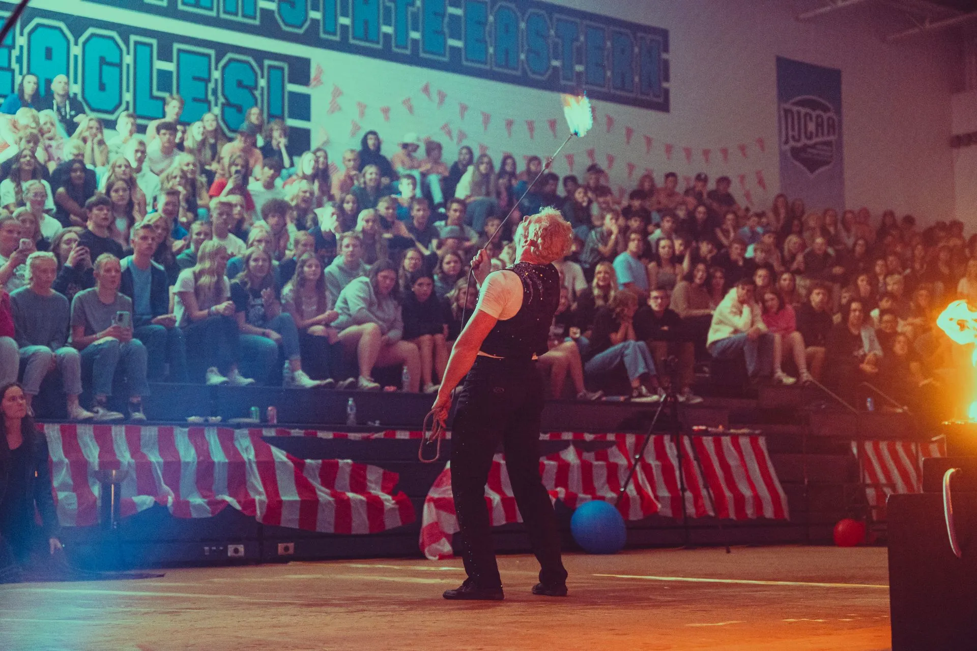 A man is standing on a stage in front of a crowd of people.