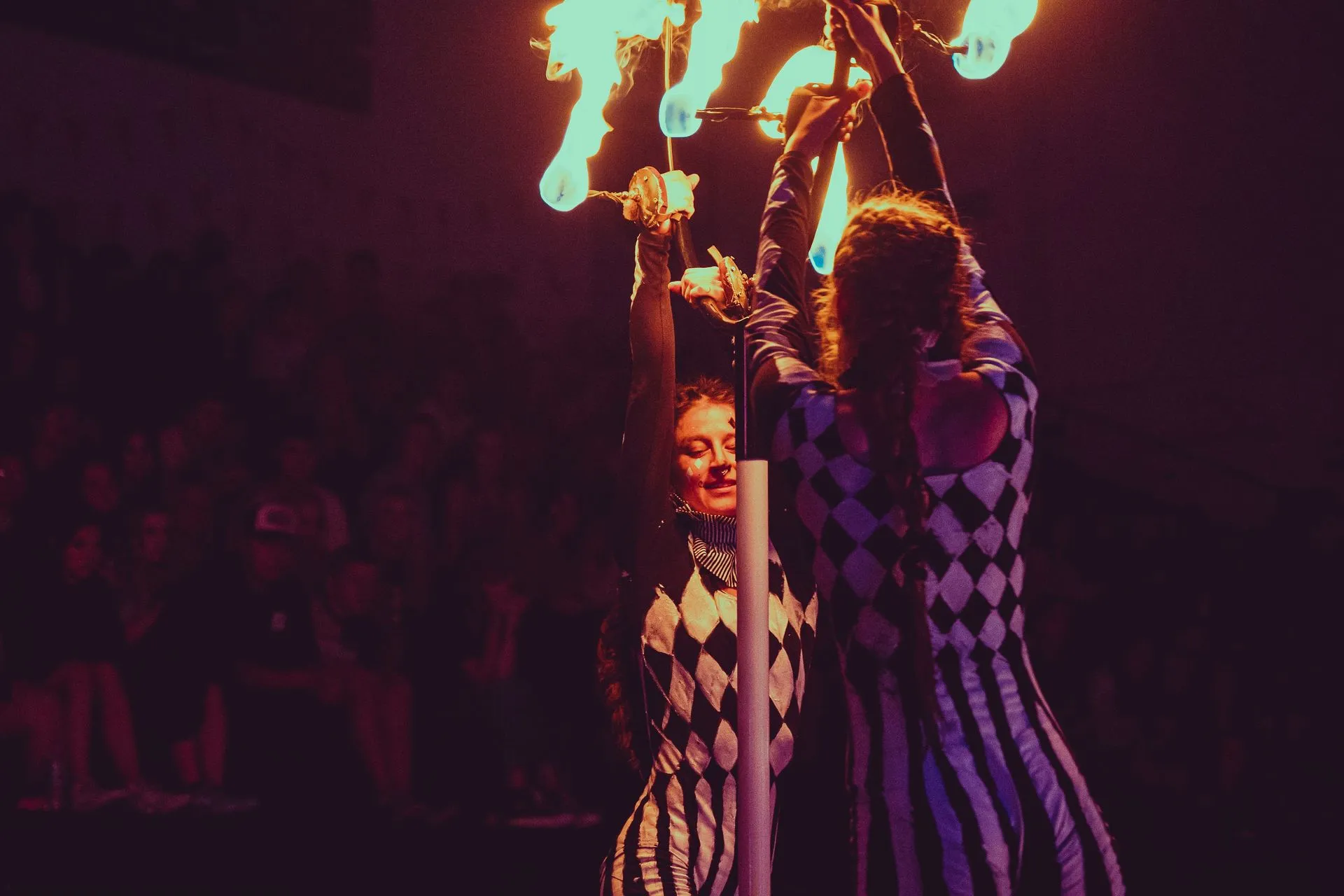 A man and a woman are holding a pole with flames coming out of it.