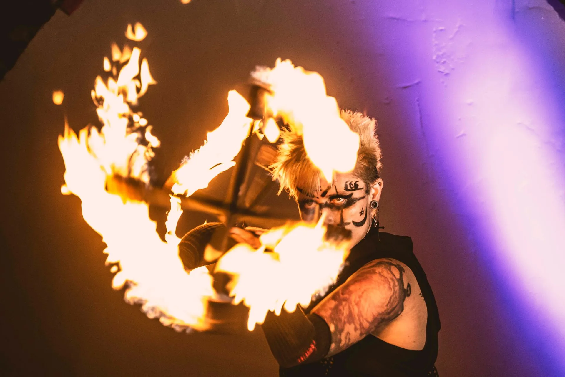 A woman performing with a dragon staff looking through the flames.