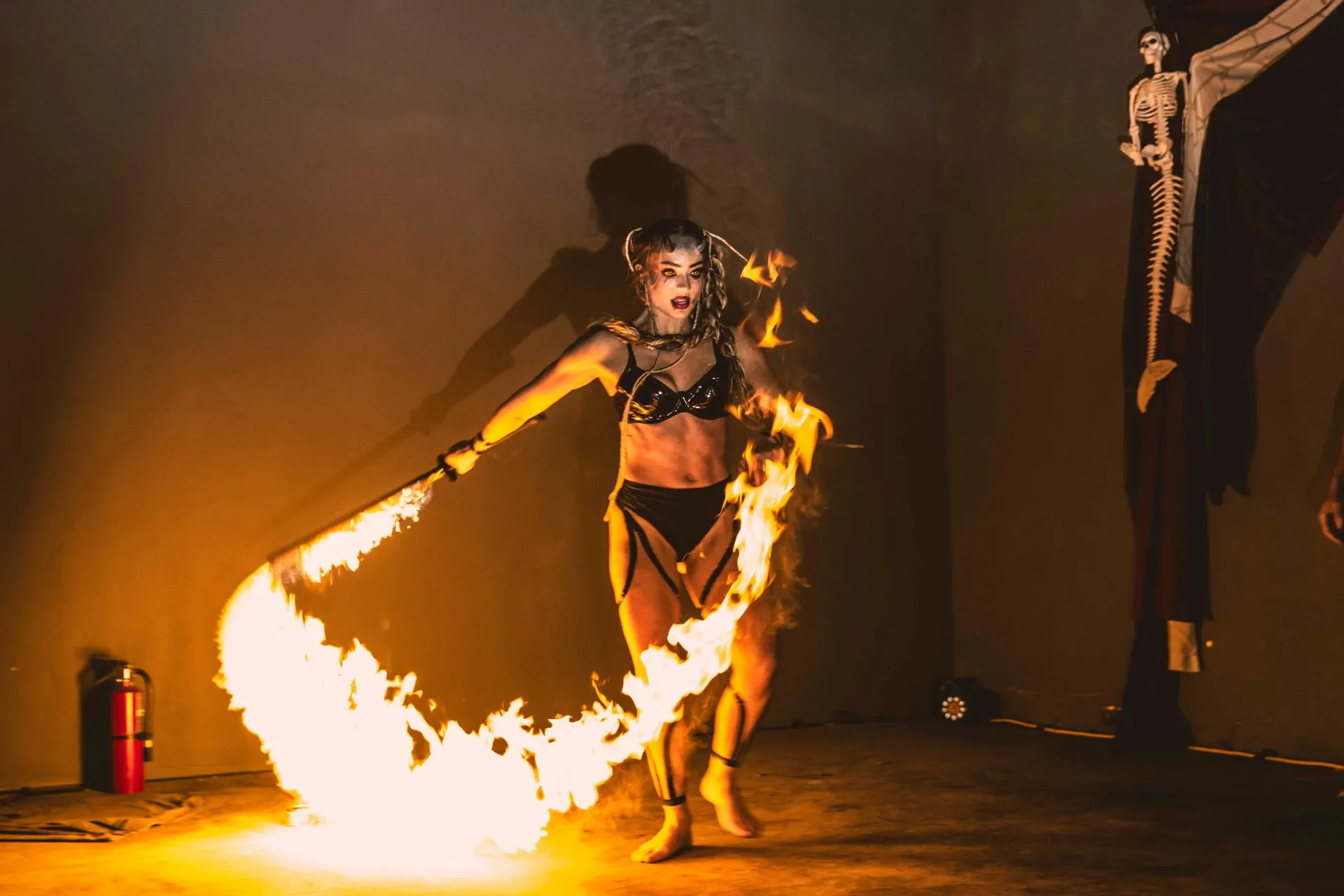 A woman is holding a torch of fire in her hand.