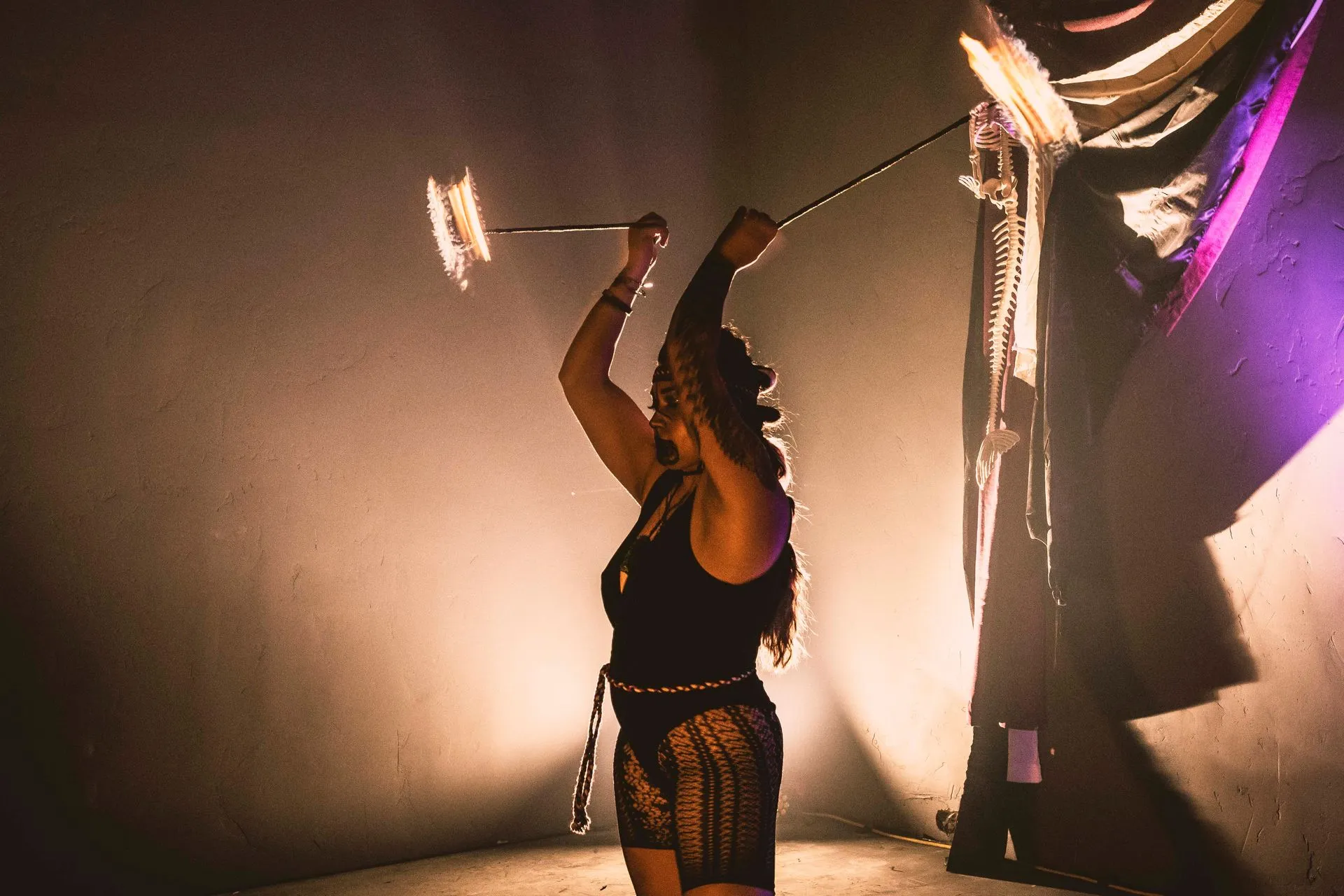A woman performing with fire poi.
