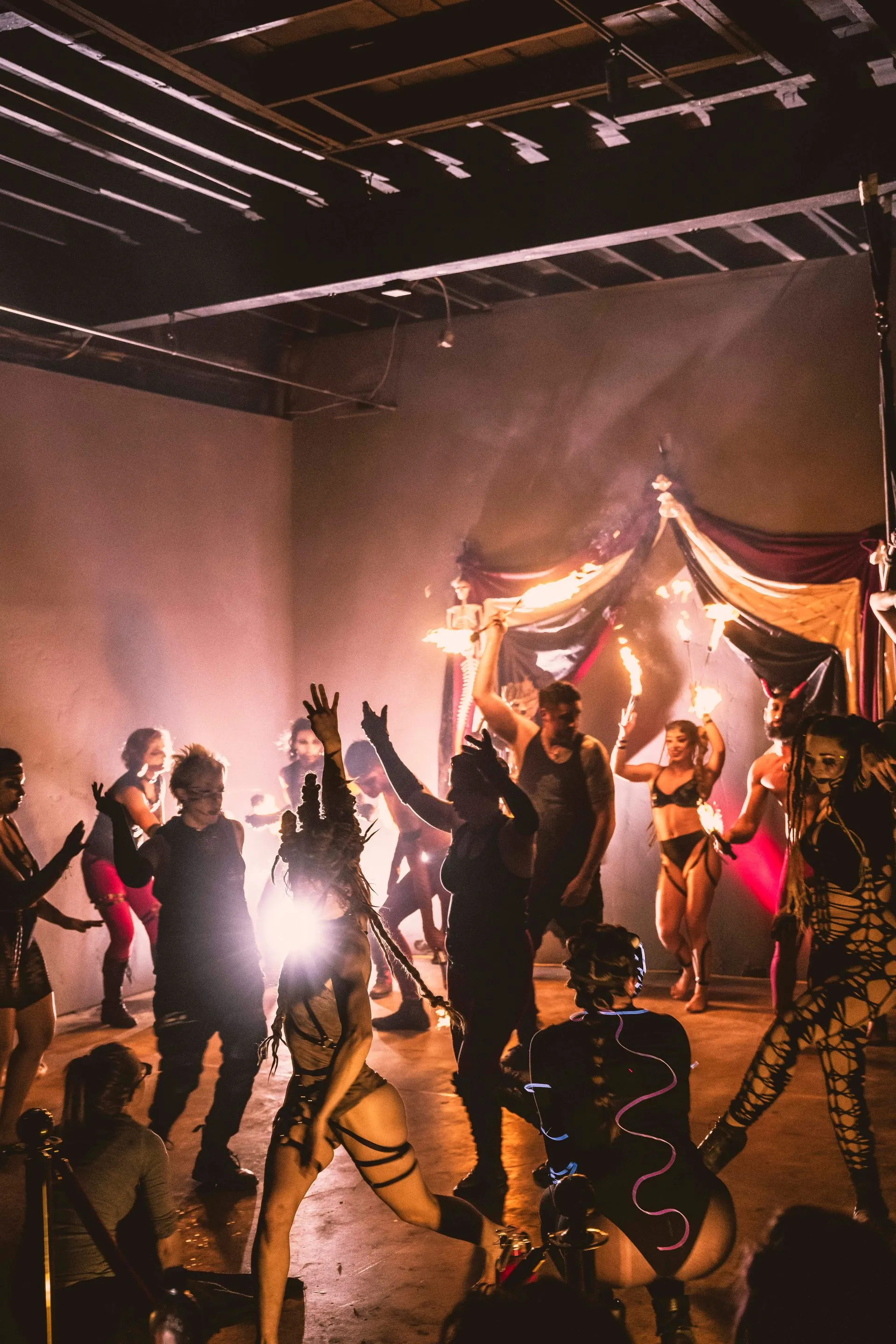 A group of people are dancing in a dark room.