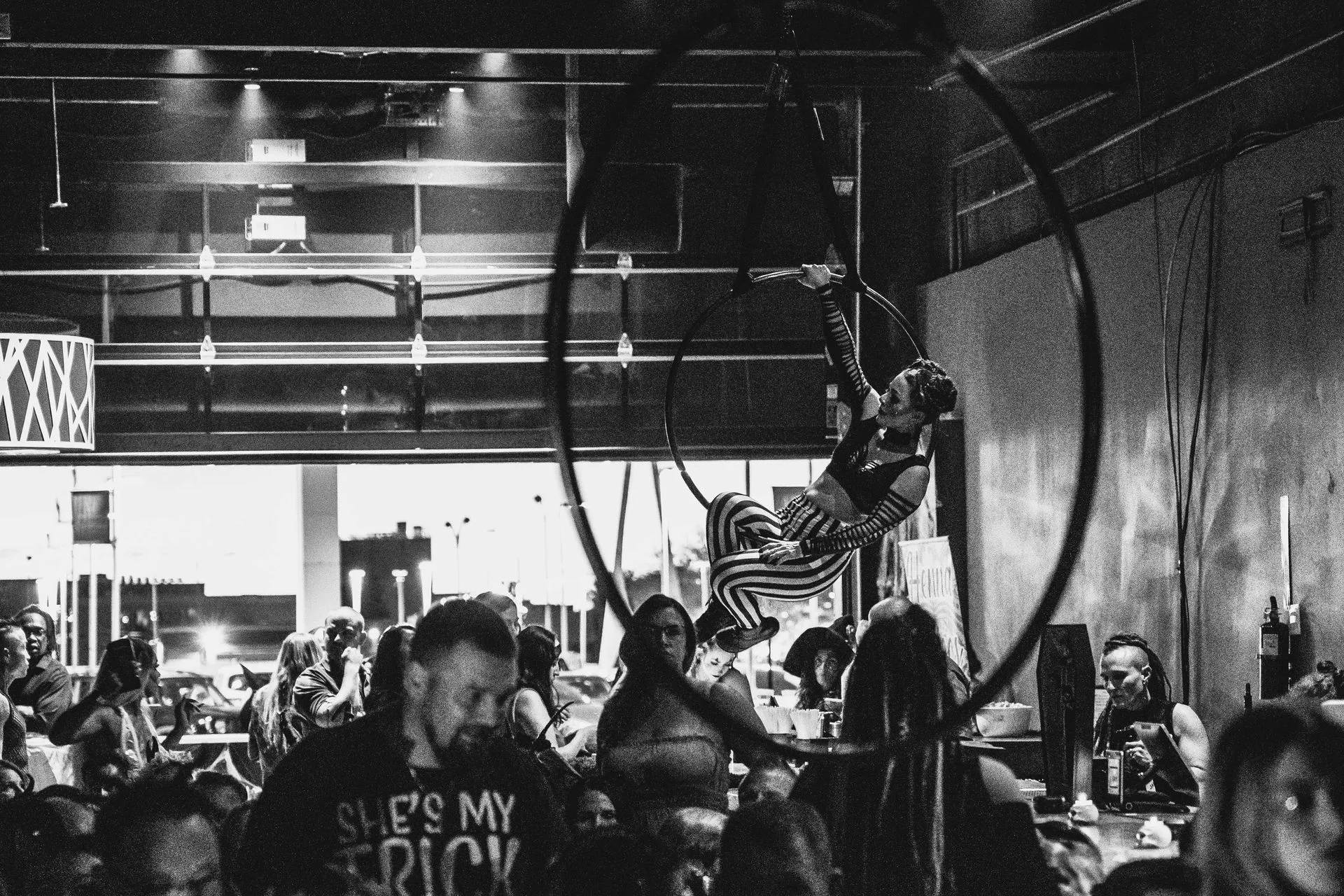 A black and white photo of a group of people in a restaurant.