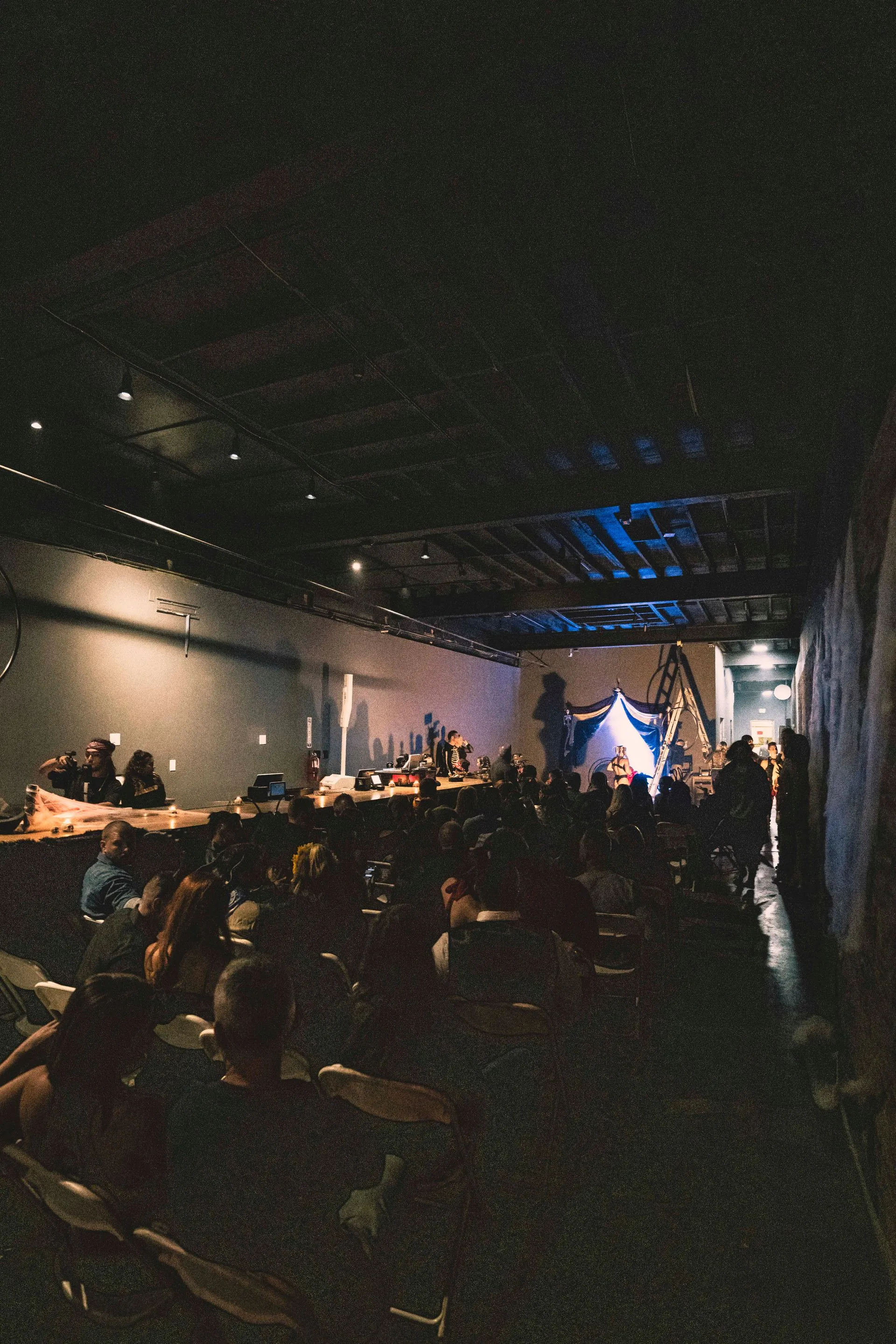 A group of people are sitting in a dark room watching a concert.