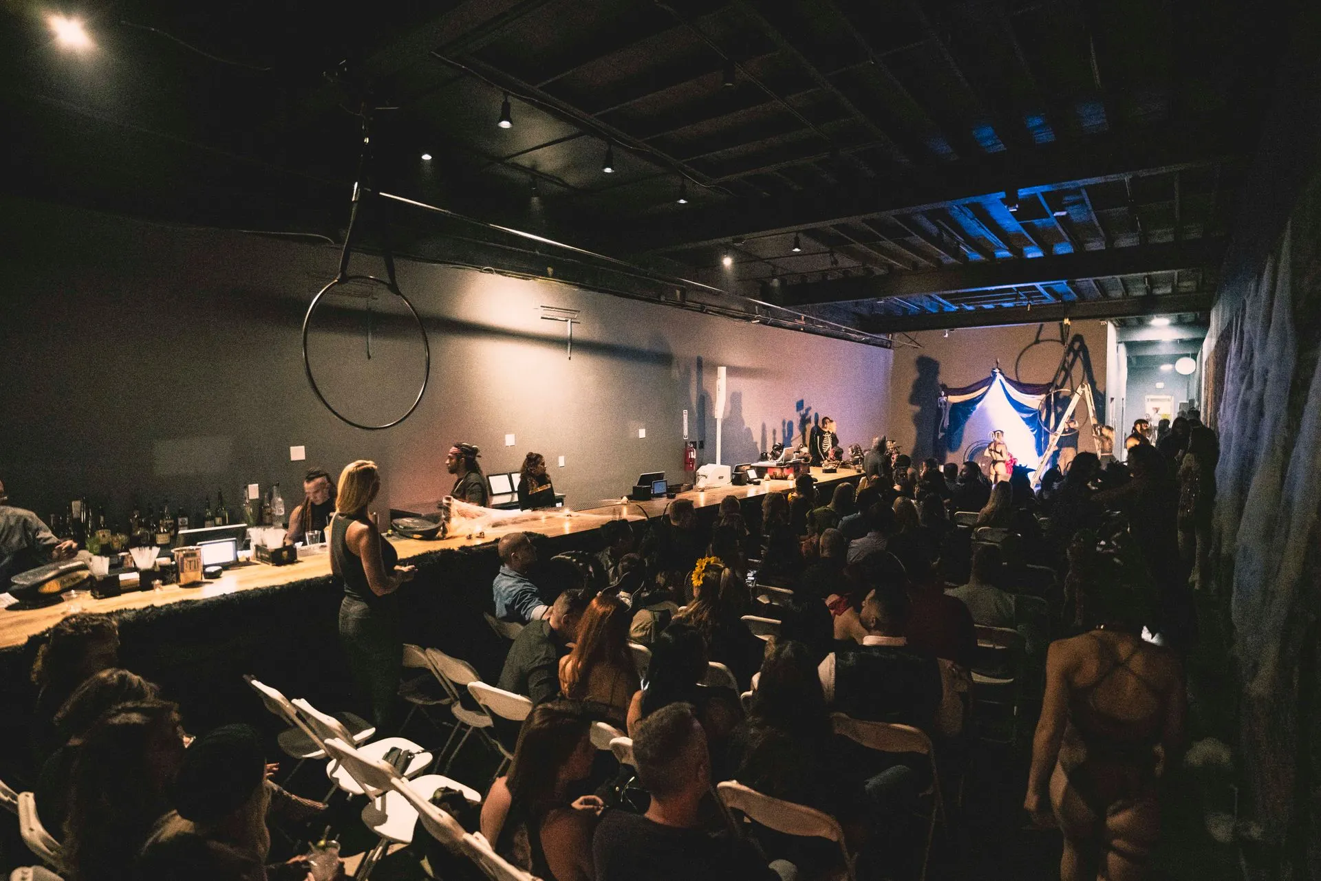 A large group of people are sitting in a dark room.