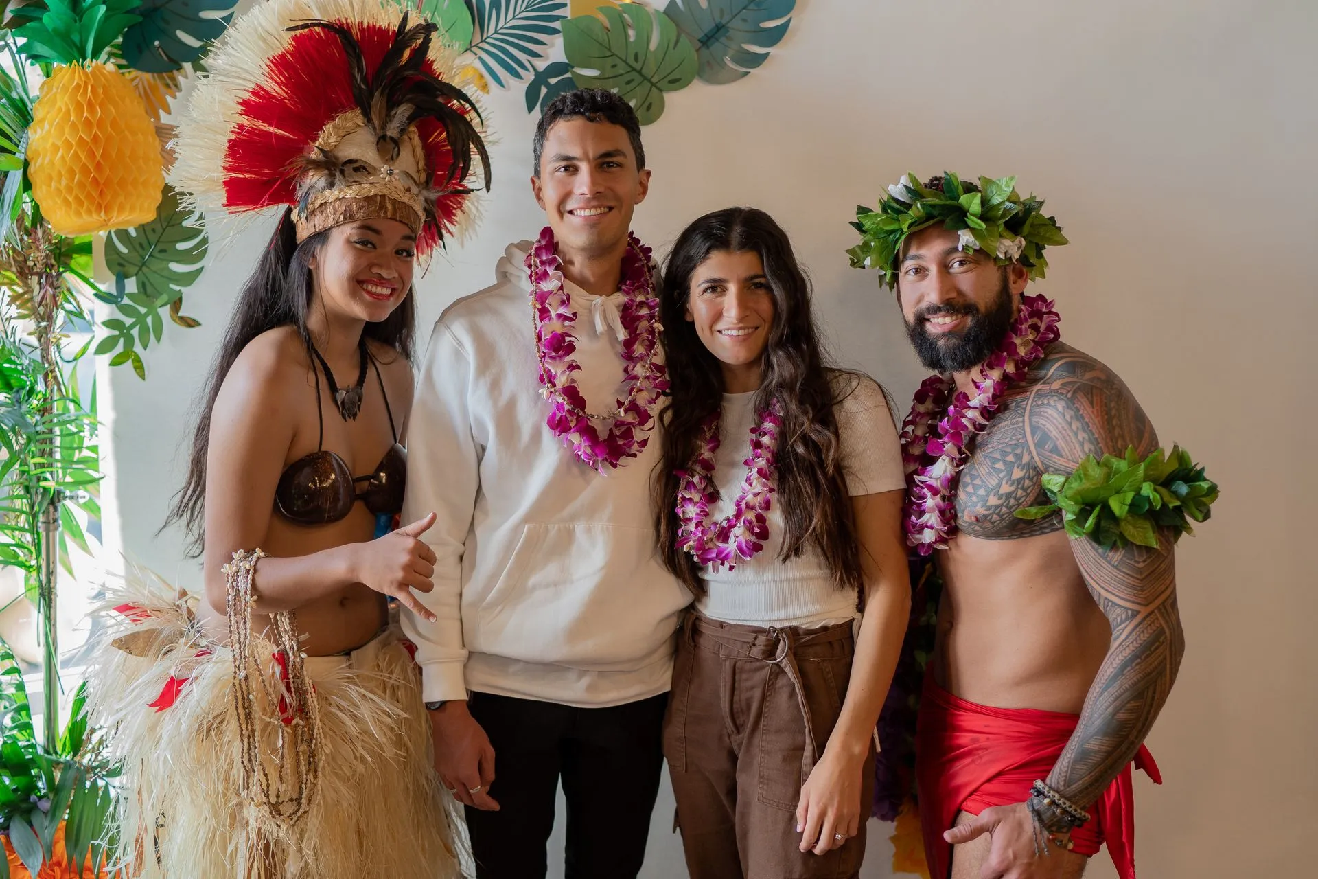 A group of people in hawaiian costumes are posing for a picture.