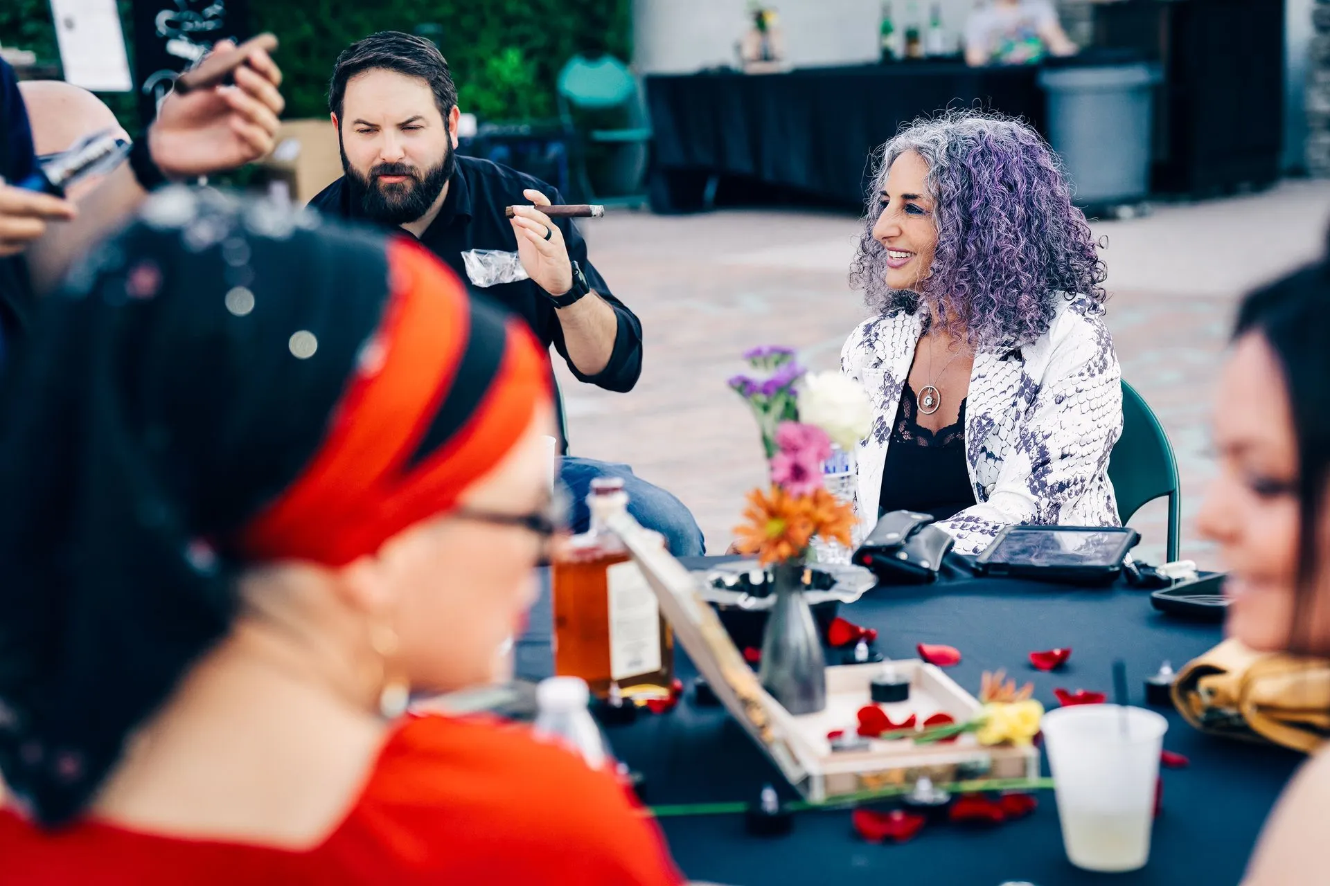 A group of people are sitting around a table talking to each other.