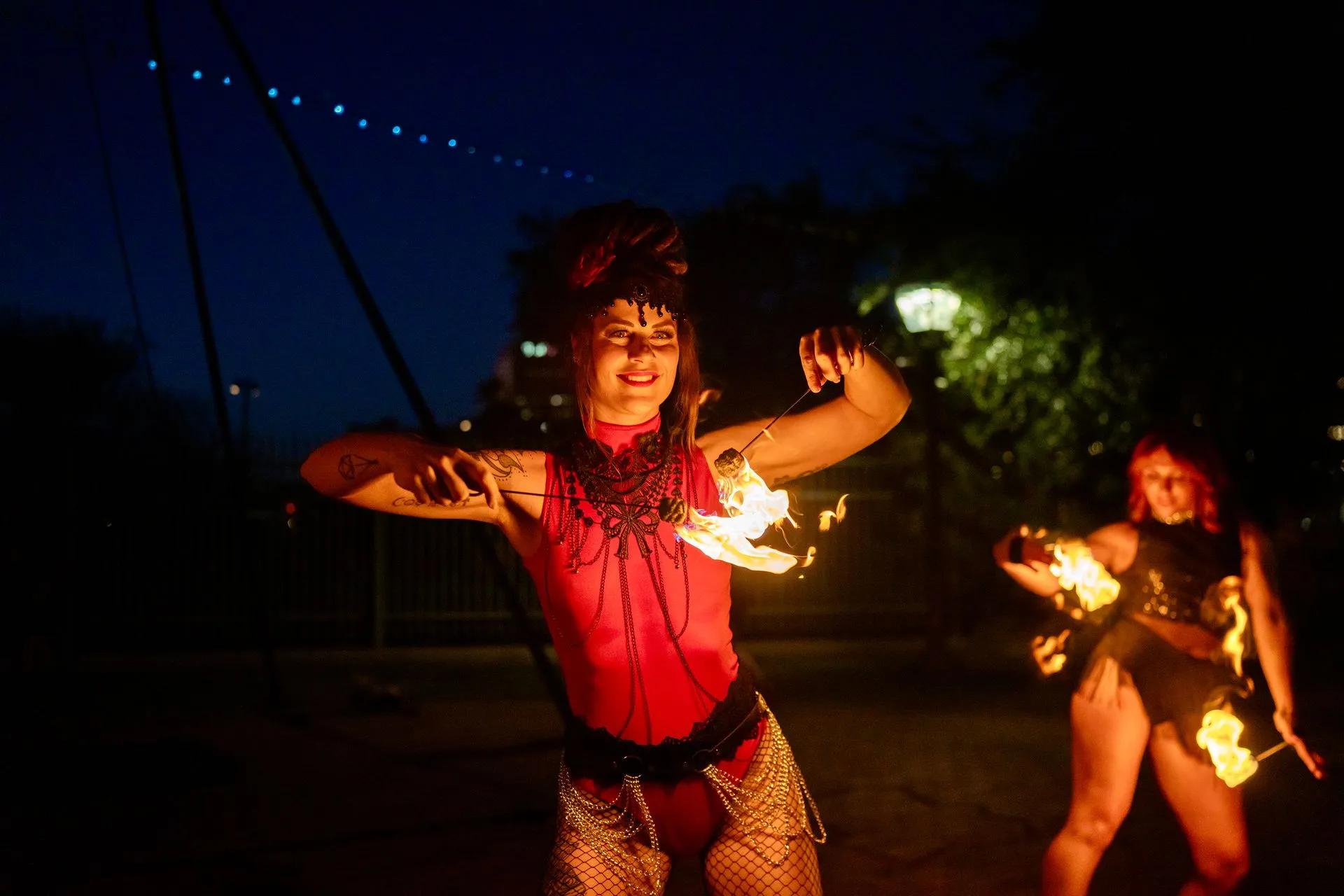 Female fire performers with small fire torches.