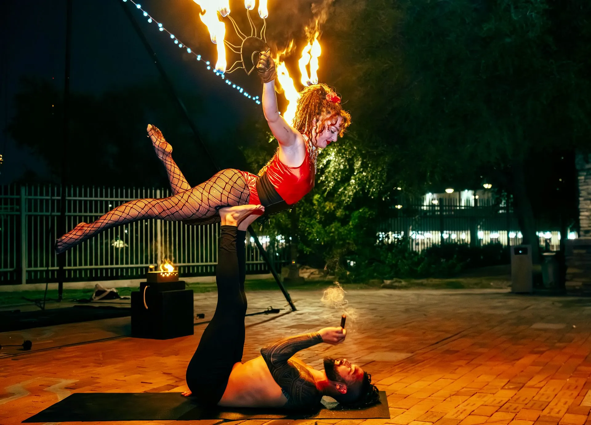 A man is holding a woman on his shoulders while she is flying through the air.