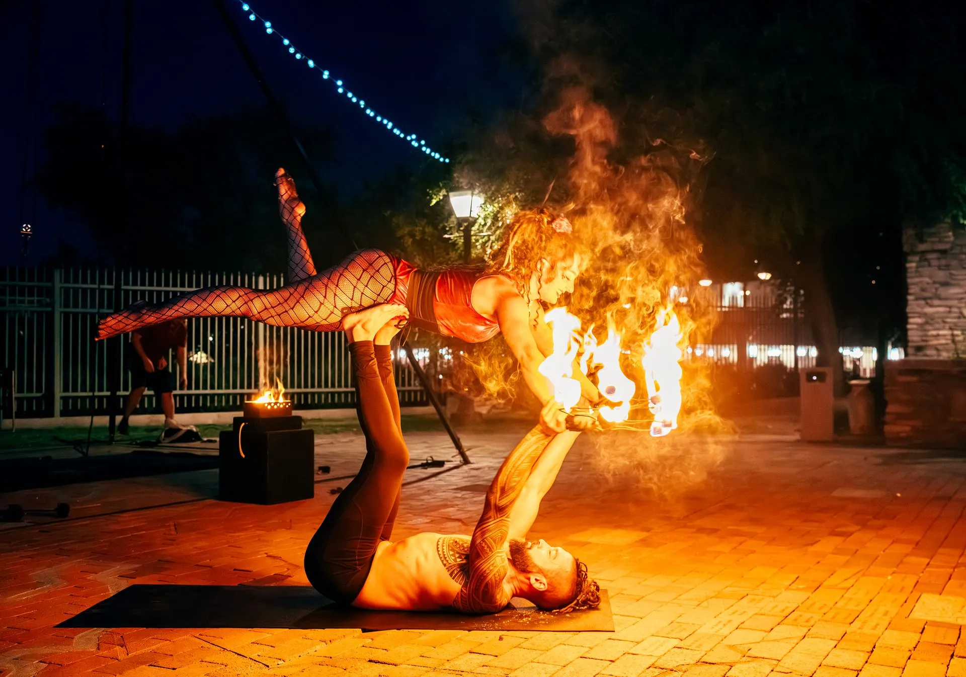 A man and a woman are doing a trick with fire.
