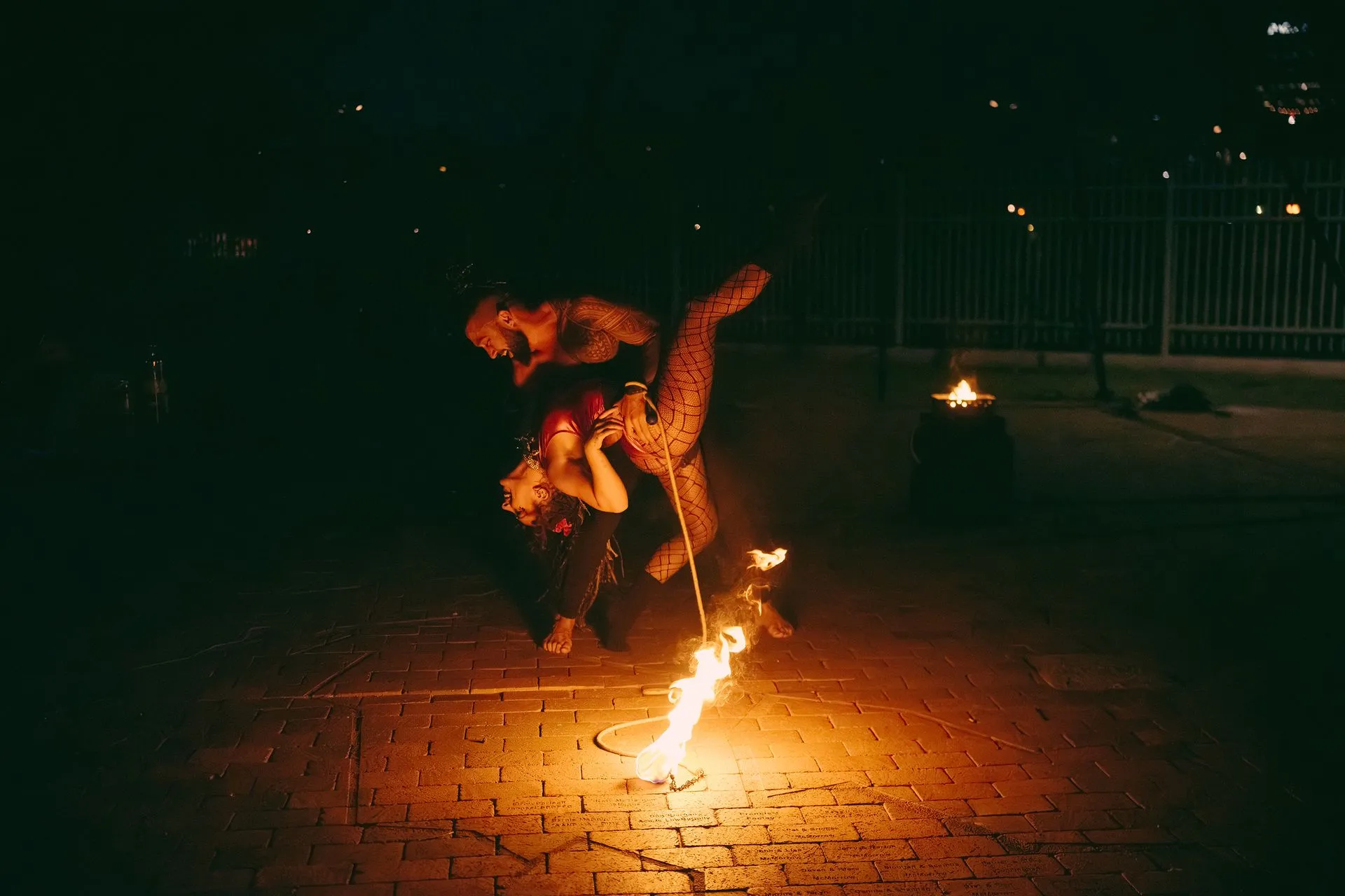 A group of people are standing around a fire at night.