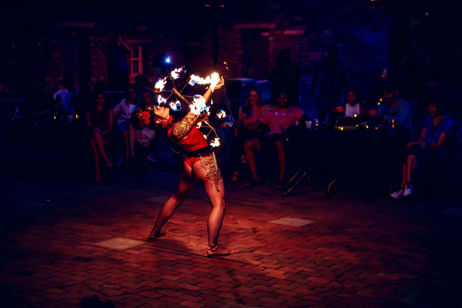 A woman is dancing with fire in a dark room.