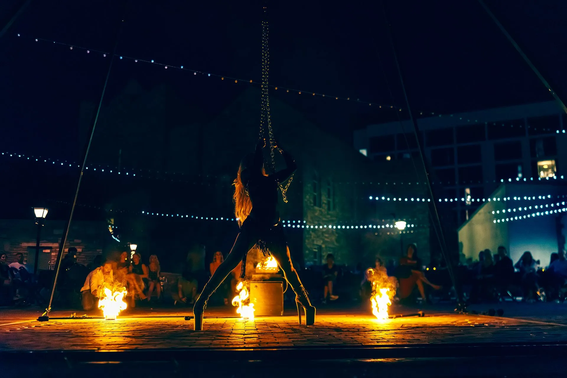 A man is standing on a stage with fire coming out of his hands.